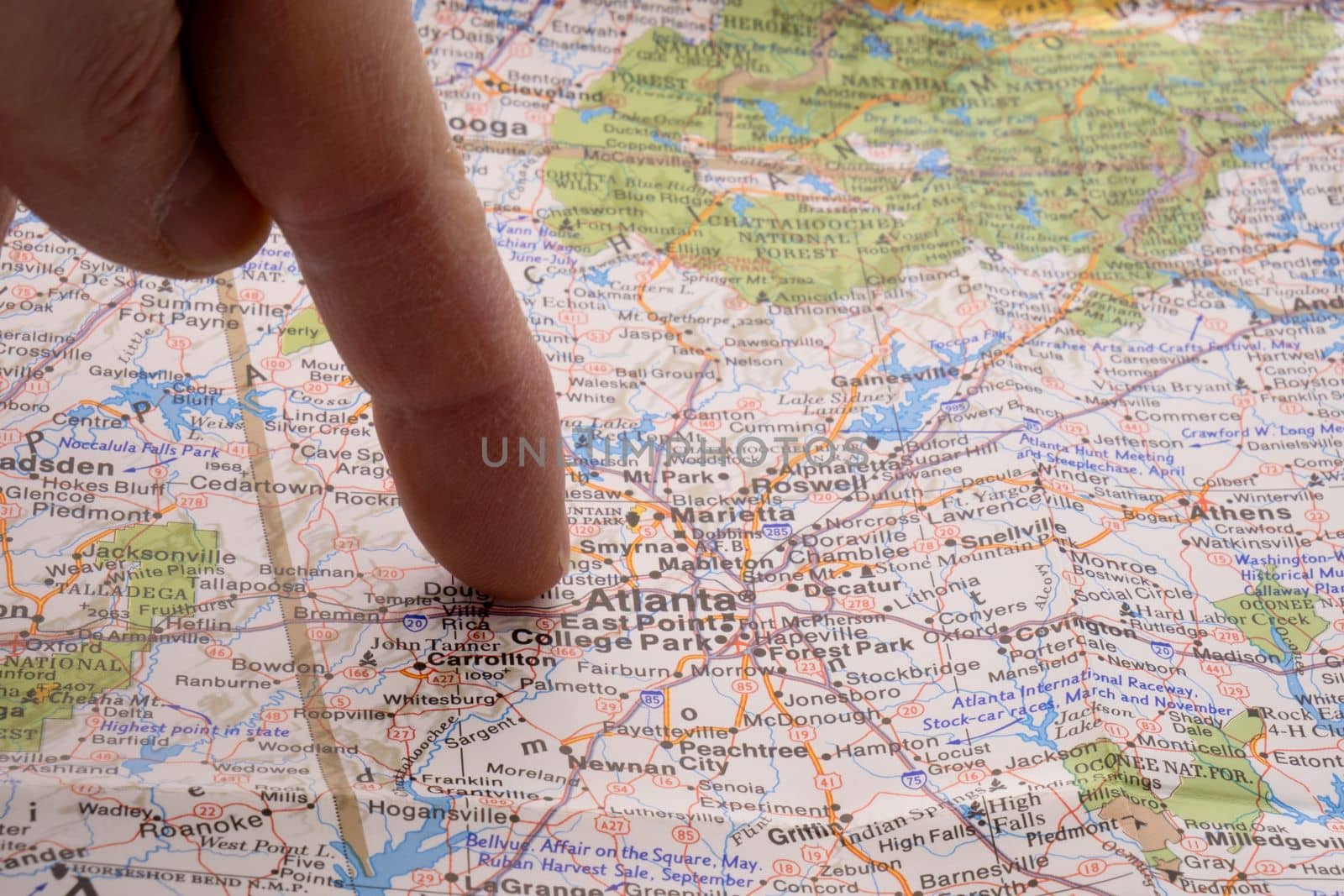 Close up of finger pointing to Atlanta, Georgia on colorful map with shallow depth of field, background blur. Concept geopolitics. High quality photo