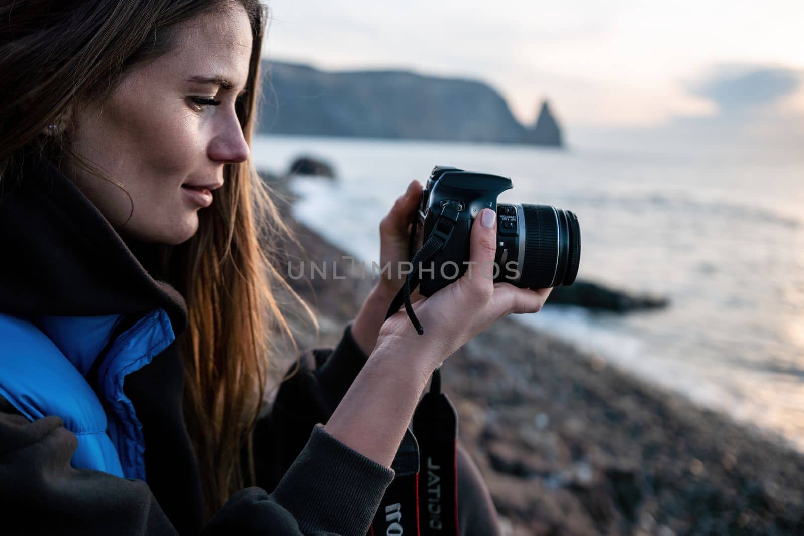 Woman travel sea. Happy tourist taking picture outdoors for memories. Woman traveler looks at the edge of the cliff on the sea bay of mountains, sharing travel adventure journey.