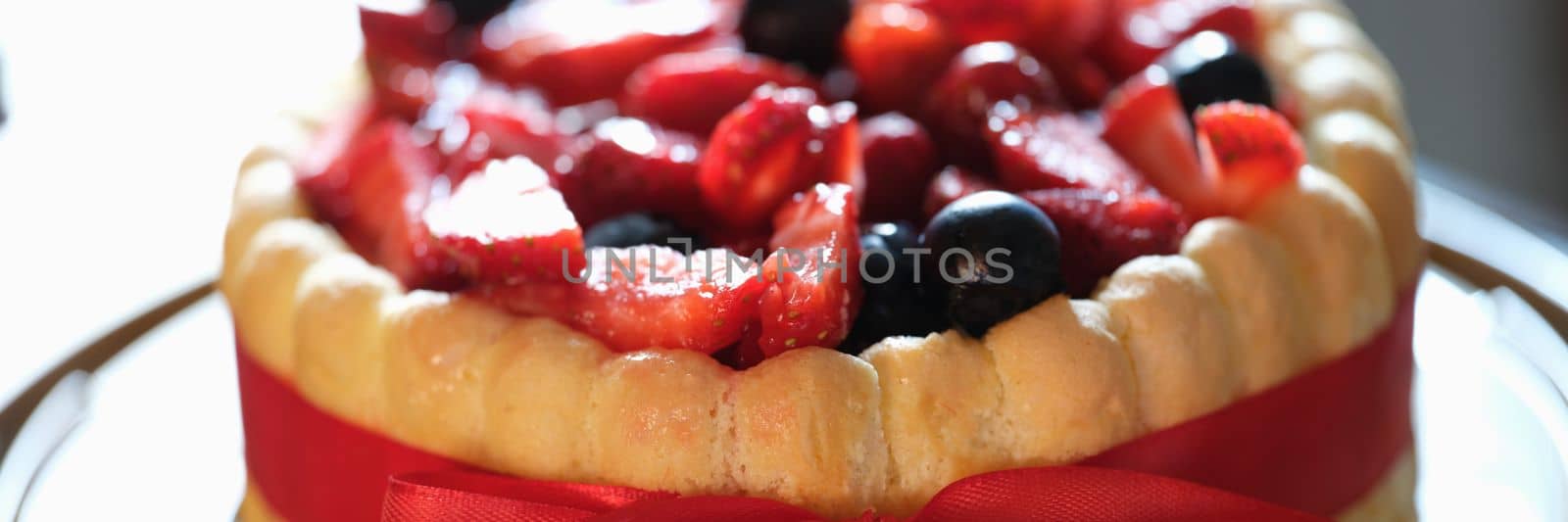 Fresh berry sweet fresh pie with red ribbon. Festive pie concept
