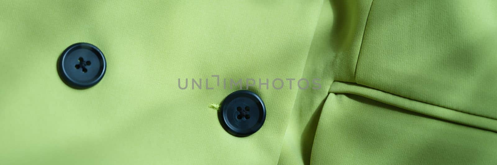 Closeup of custom made green jacket with black buttons. Strict business jacket and details