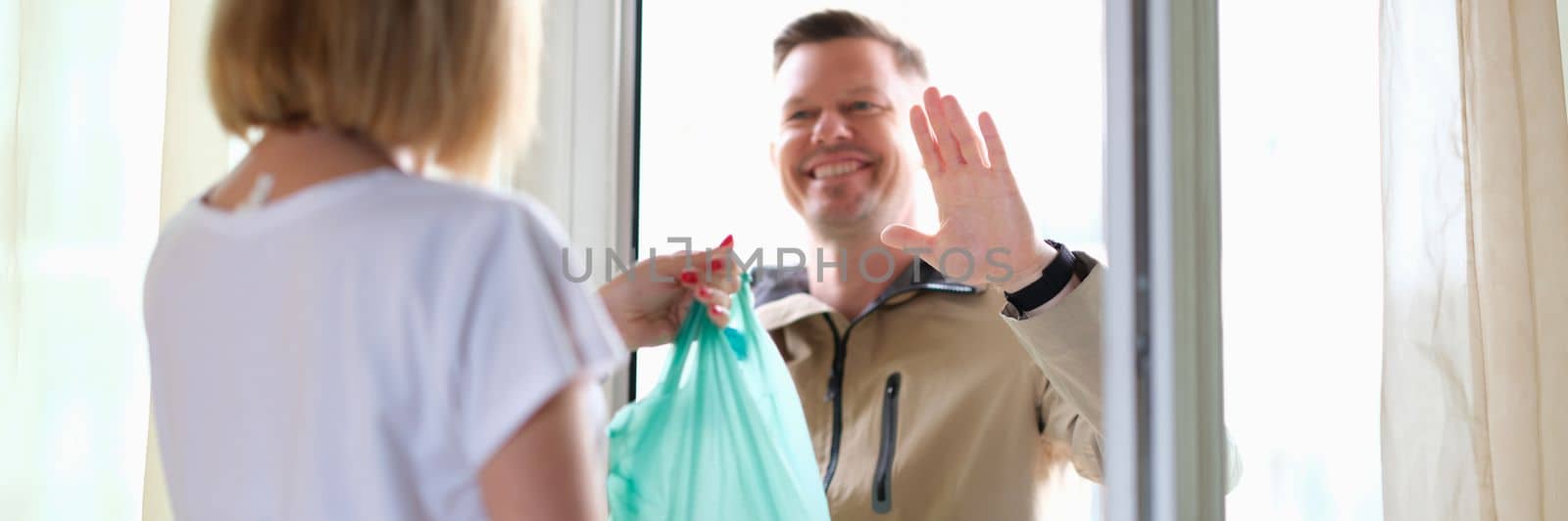 Male courier brought a package with groceries and delivery of goods. Parcel delivery service concept