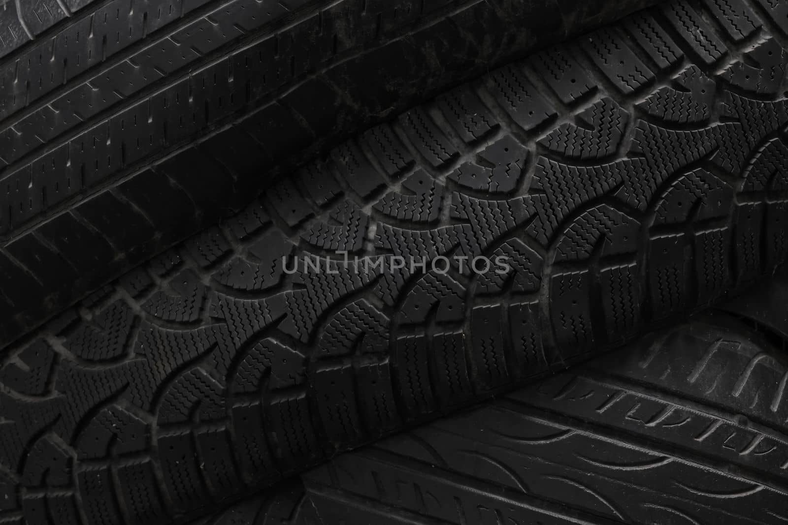Old used black car or truck wheel tires background