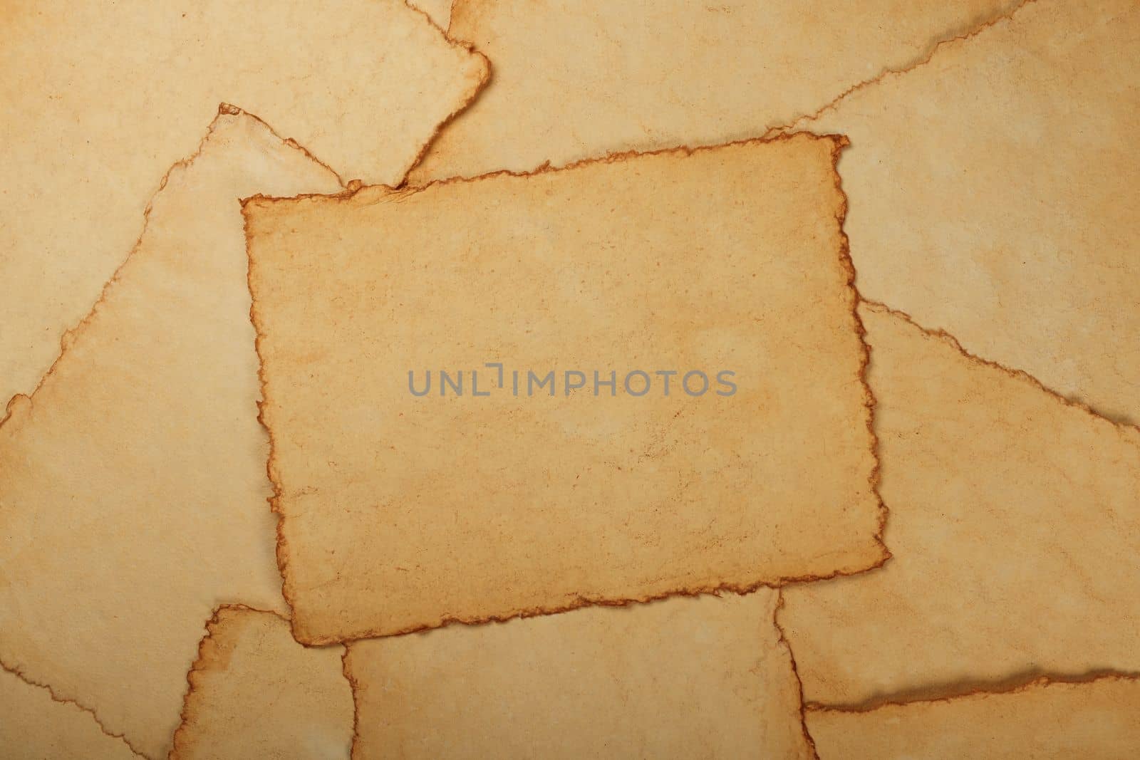Close up background texture of blank old antique vintage brown paper parchment sheets with dark aged and weathered edges