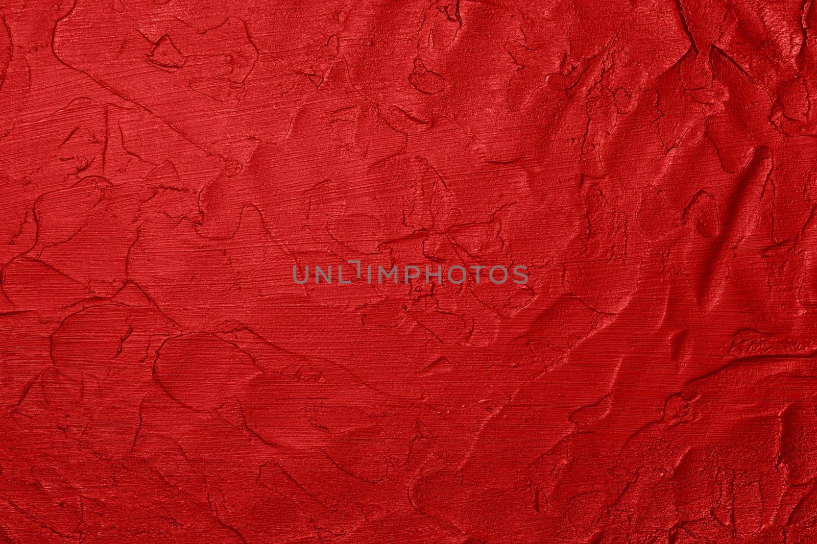 Close up vivid scarlet red abstract background texture of uneven grunge surface with brushstrokes of plaster and paint