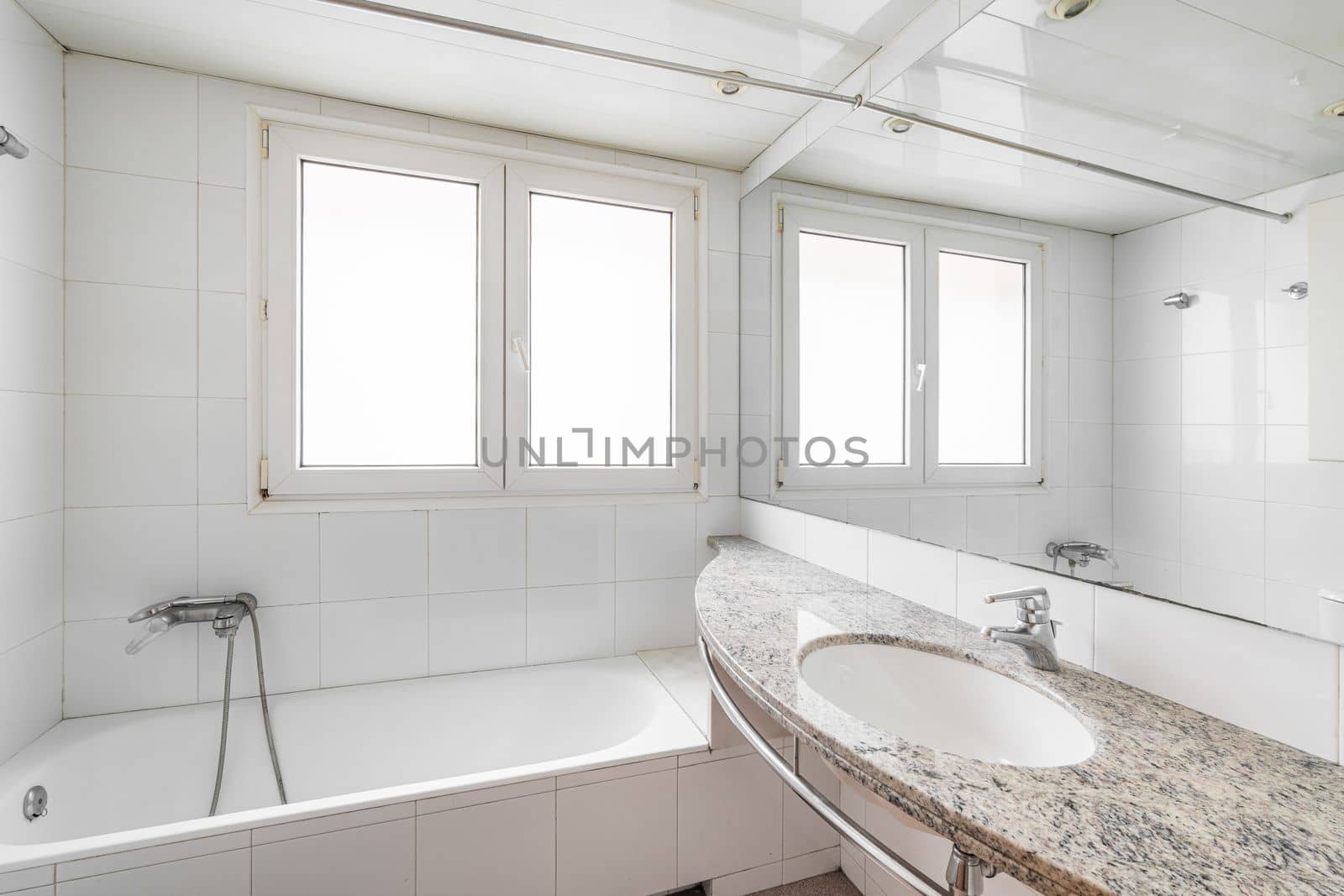 White bathroom with large hot tub. On the wall are two plastic windows with frosted glass through which daylight shines. Nearby is a sink on a marble countertop with a large mirror on the wall. by apavlin