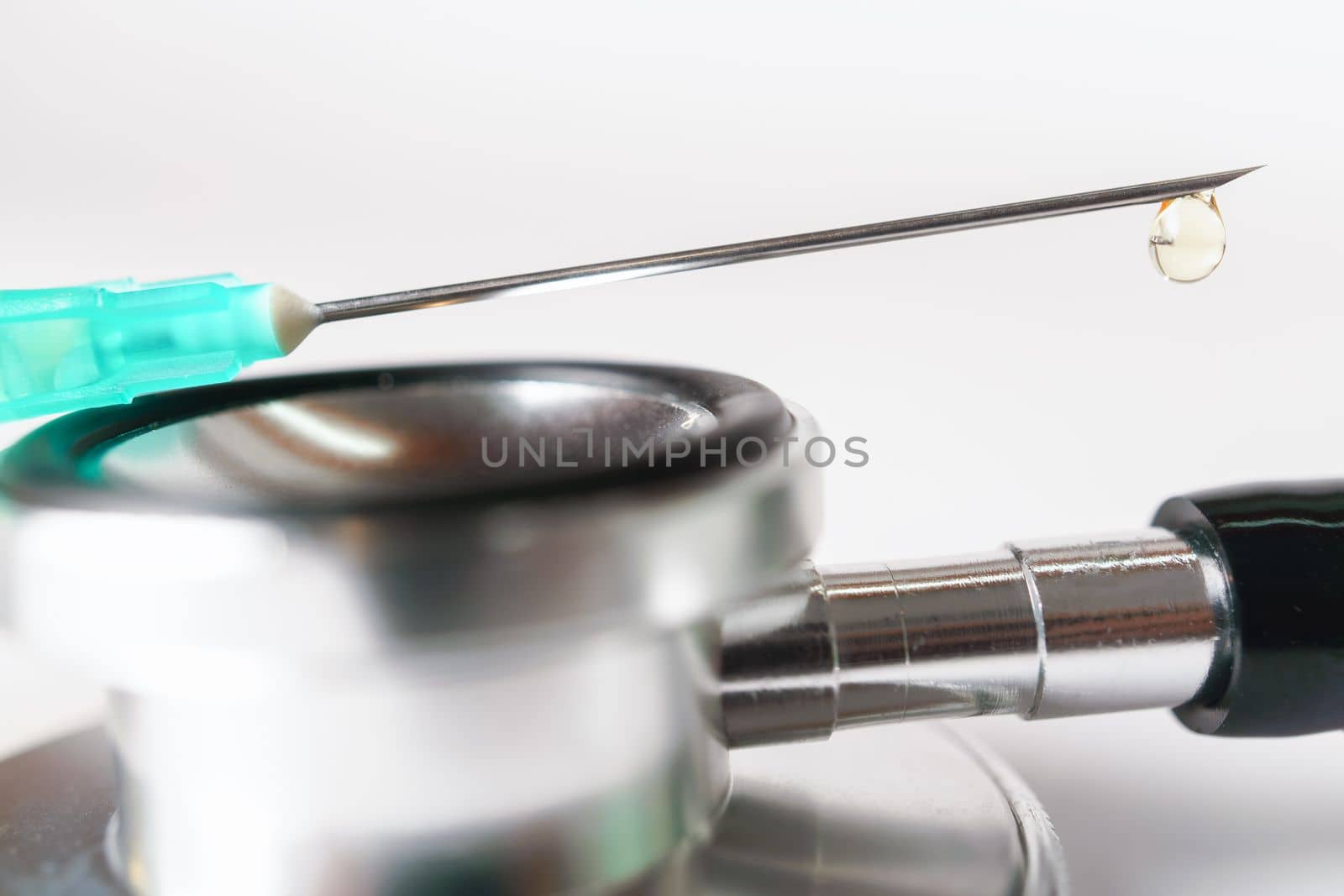 syringe, stethoscope and pills on a doctor's gown white background and copy space