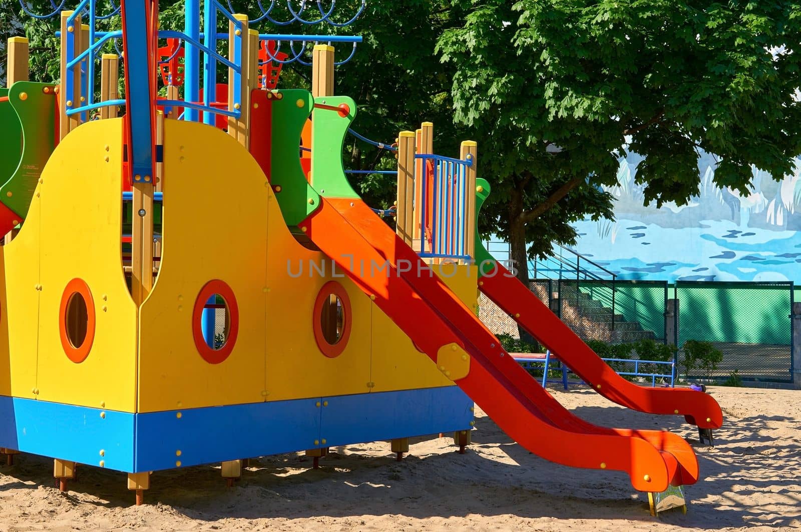 an outdoor area provided for children to play in, especially at a school or public park. Summer spring children's playground with painted toy ship in park.