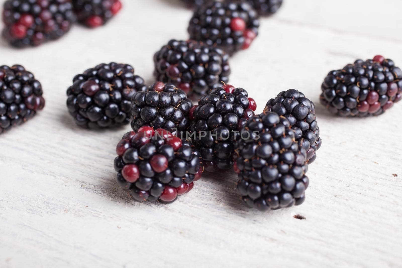Close up of delicious blackberry on white wooden table