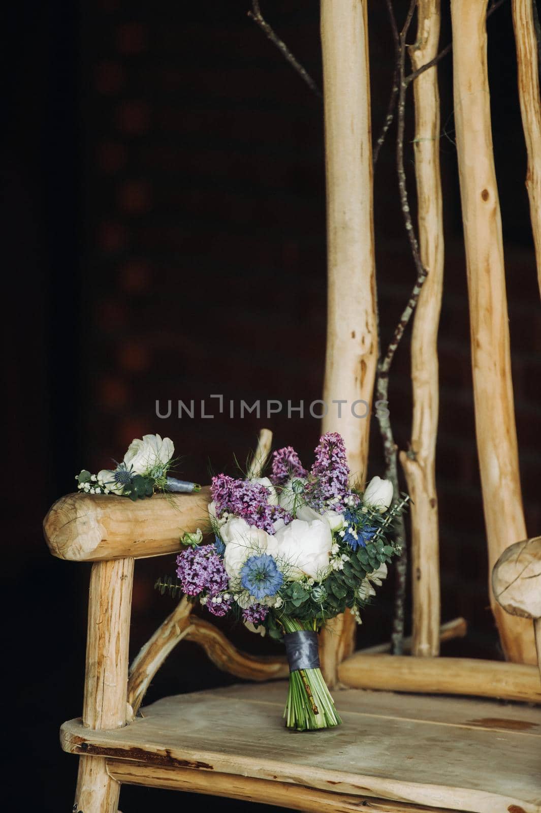 a spring Wedding bouquet of lilac and white roses lies on a decorative wooden chair.Wedding bouquet, details, wedding, decor by Lobachad