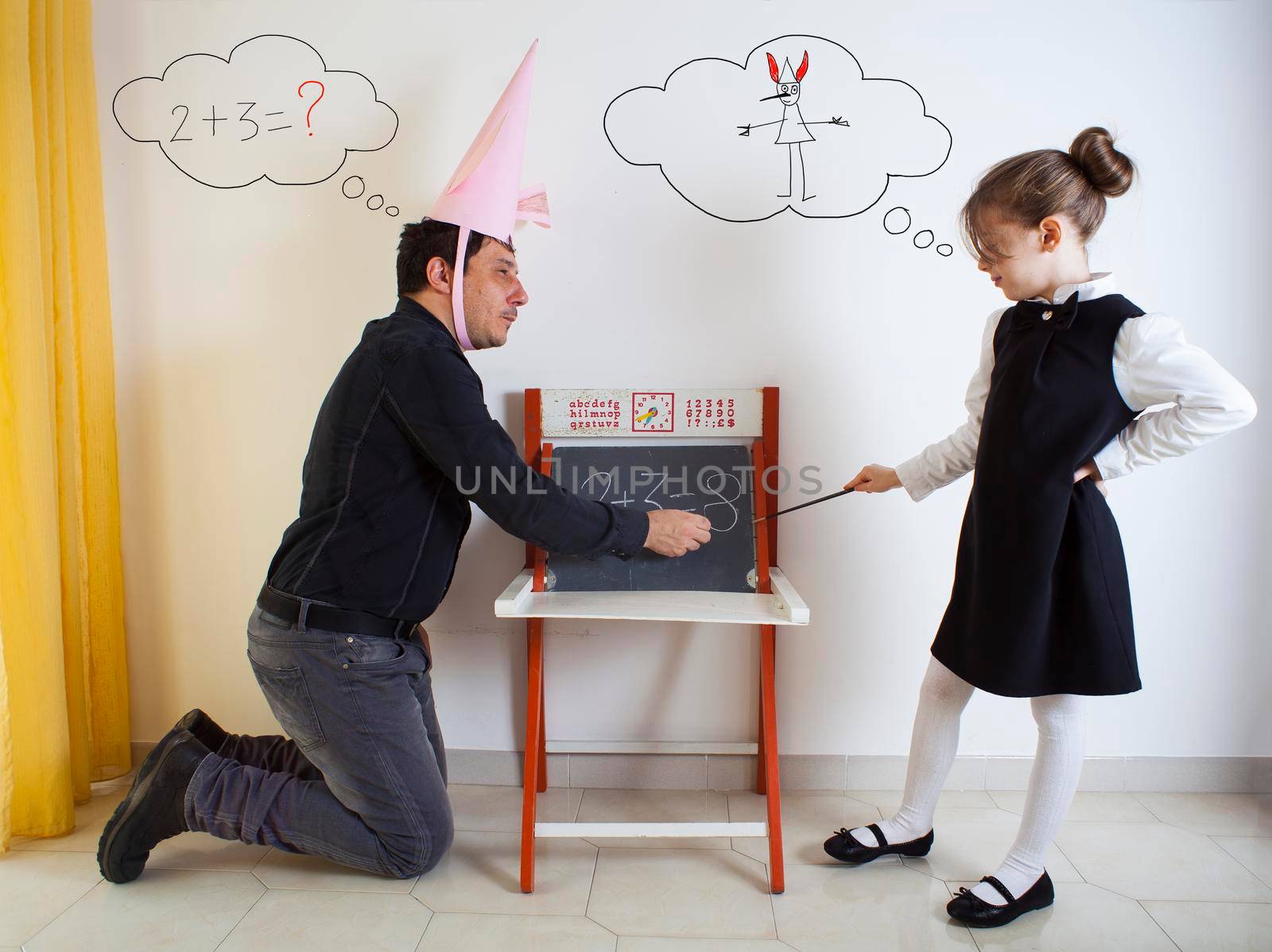 Little girl teaching mathematics to an adult dunce on little chalkboard