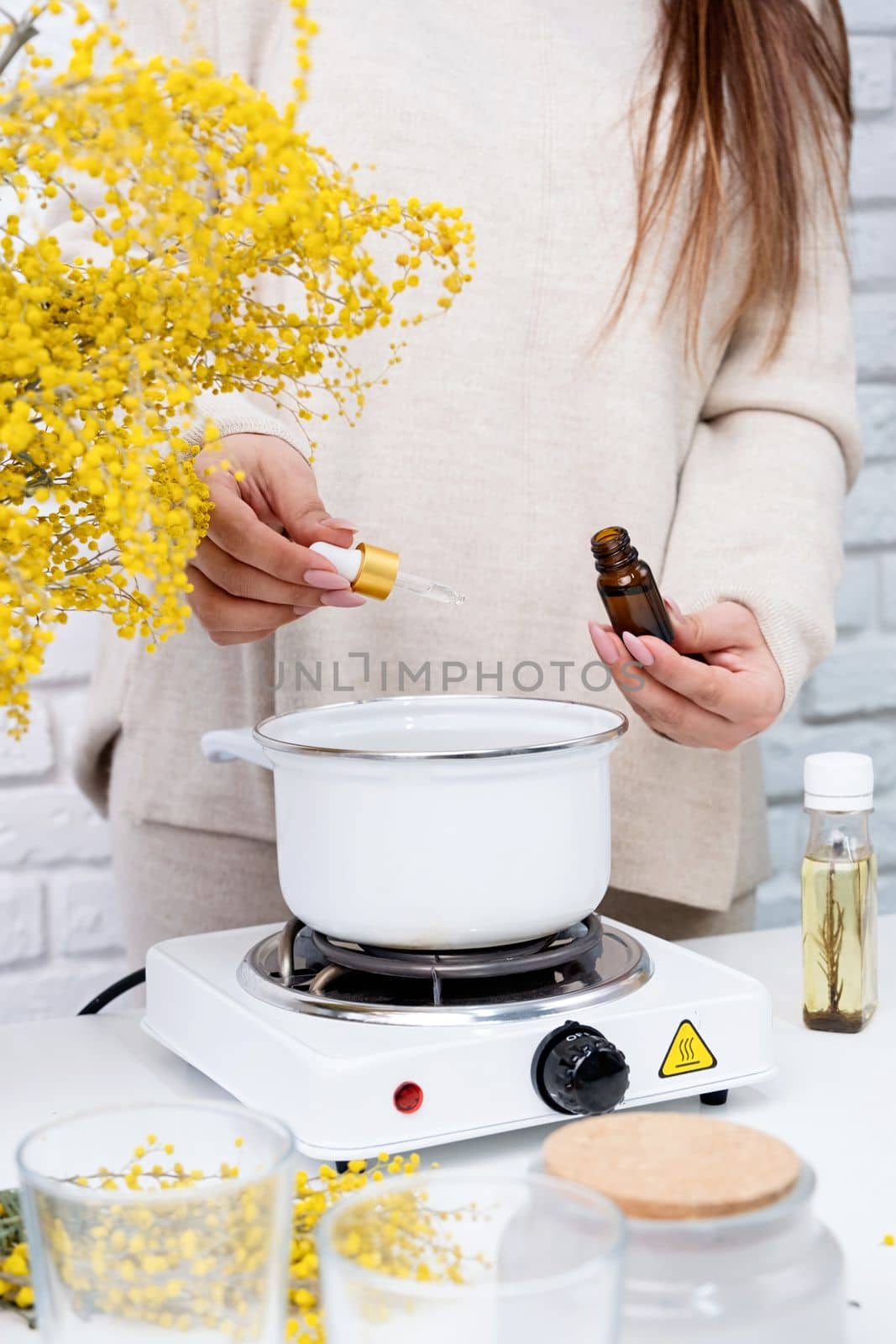 Woman making decorative aroma candle at table, closeup by Desperada