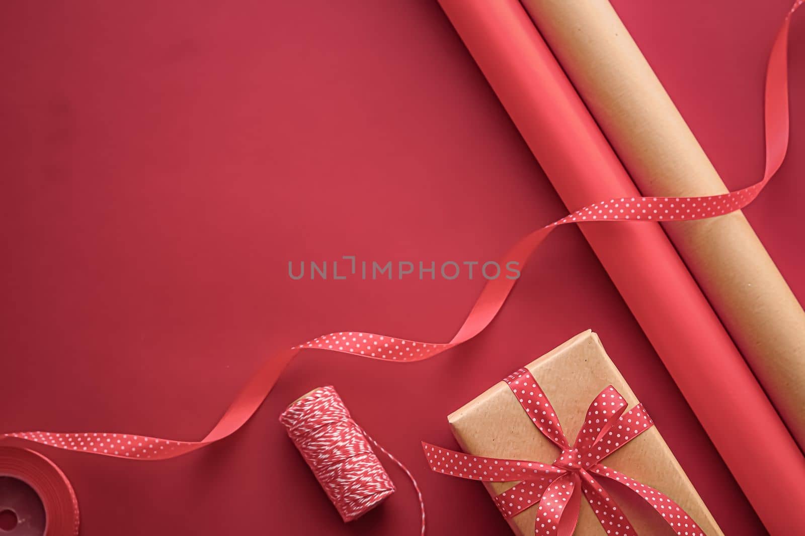 Gifts preparation, birthday and holidays gift giving, craft paper and ribbons for gift boxes on coral background as wrapping tools and decorations, diy presents as holiday flat lay design by Anneleven