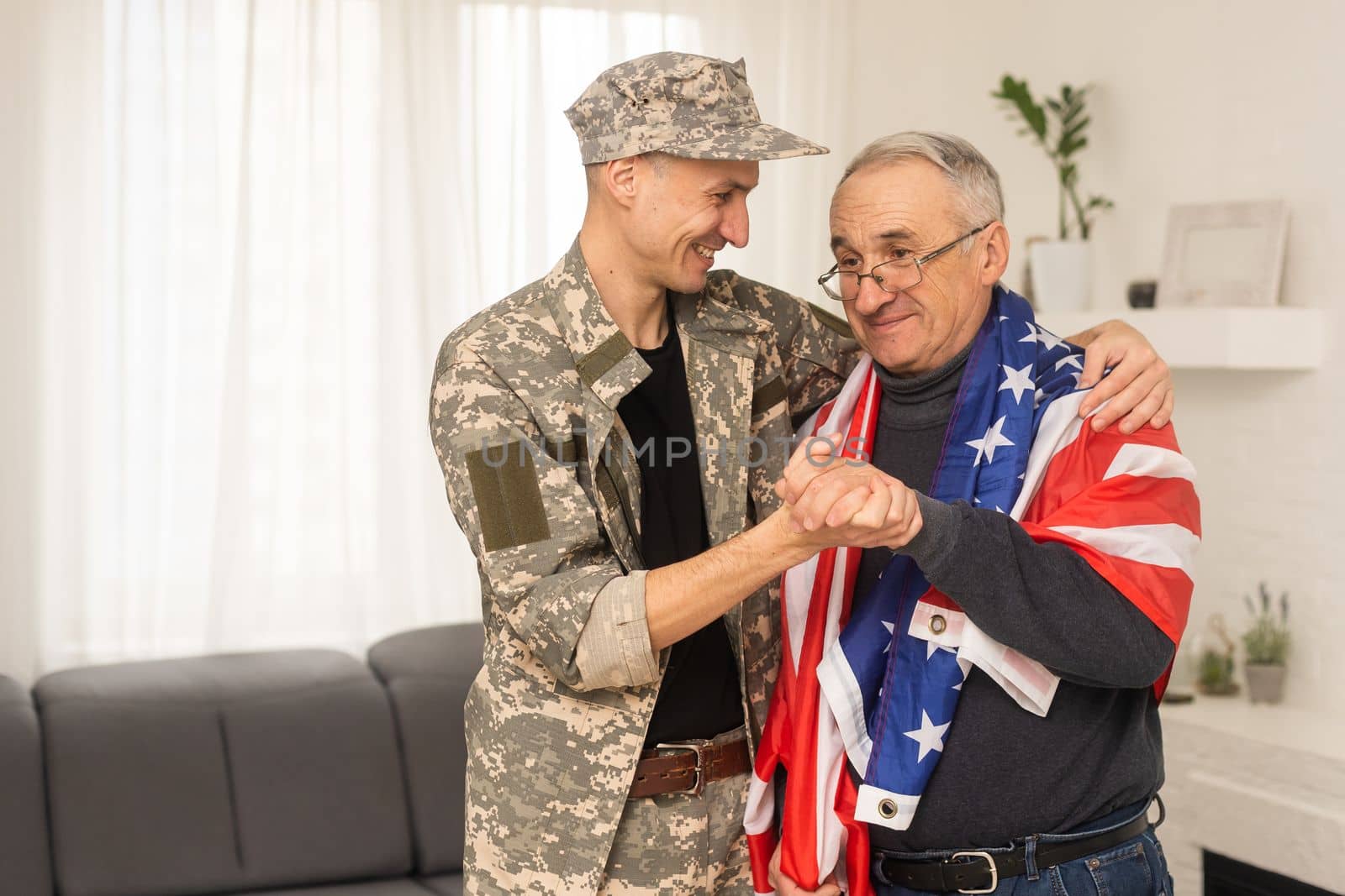 an elderly father and a military son saluting American flag by Andelov13