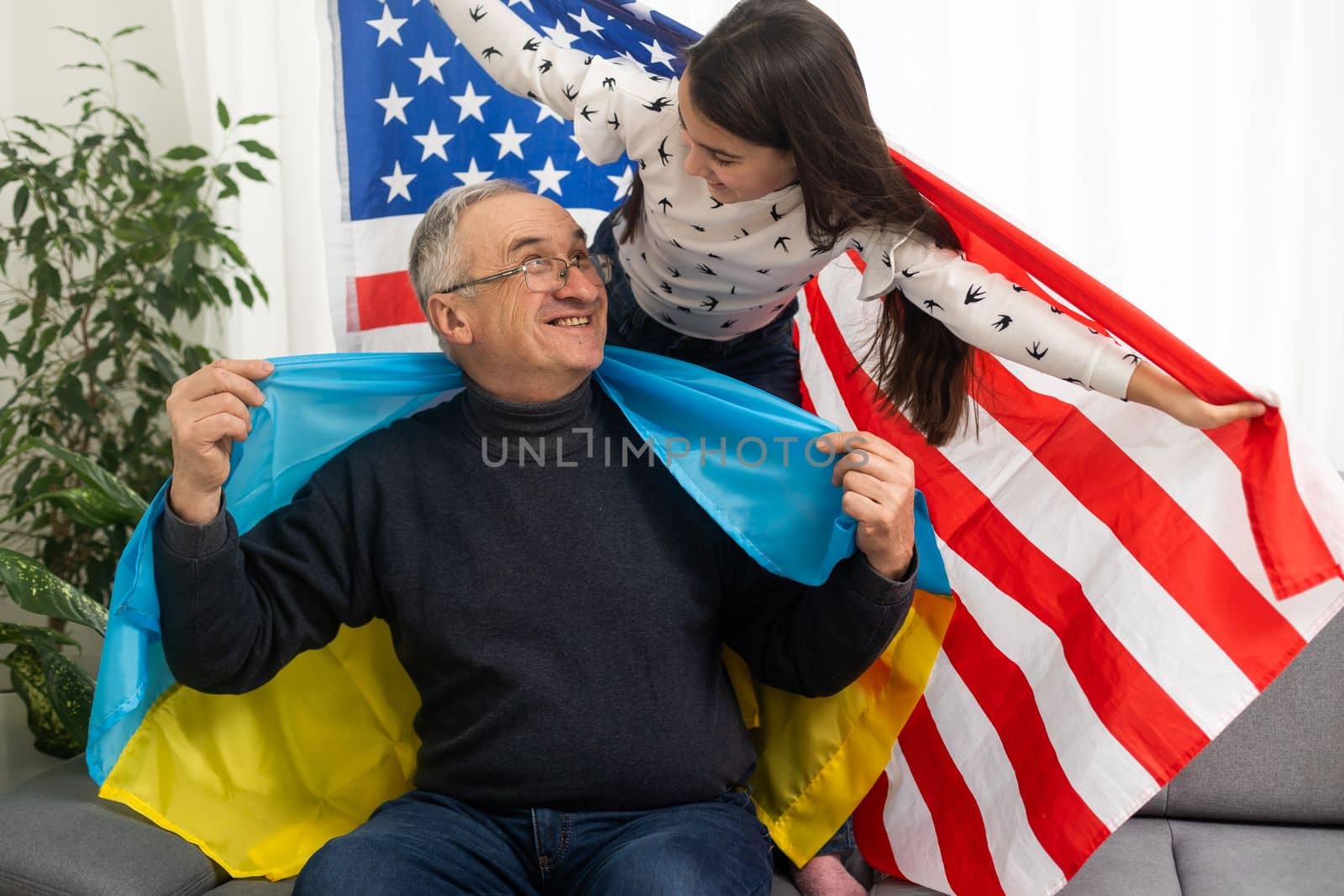 grandfather and granddaughter with the flags of the USA and Ukraine by Andelov13