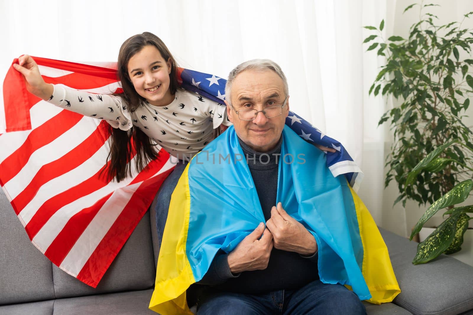 grandfather and granddaughter with the flags of the USA and Ukraine by Andelov13