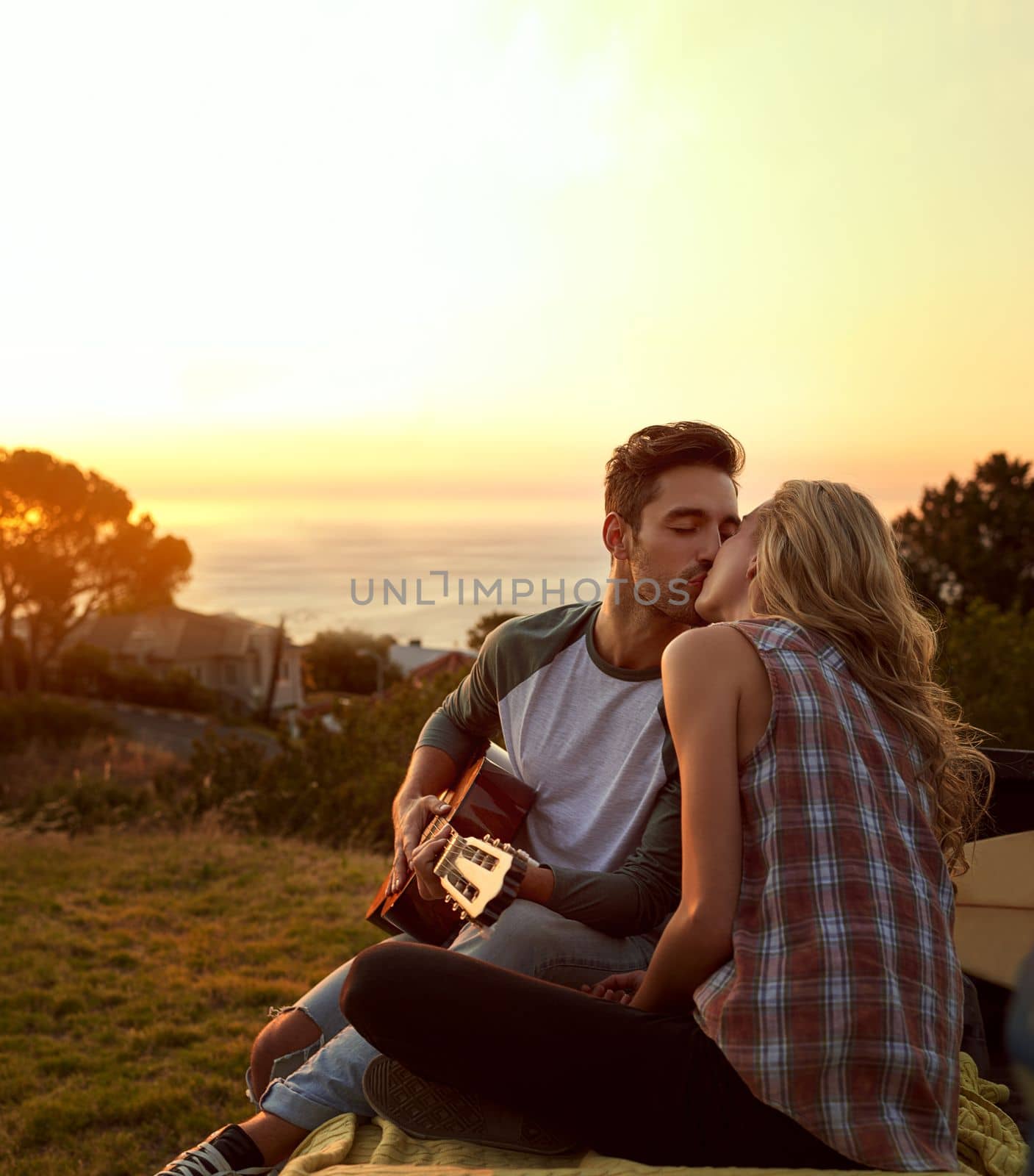 Out on a romantic roadtrip. a young man playing guitar for his girlfriend on a roadtrip