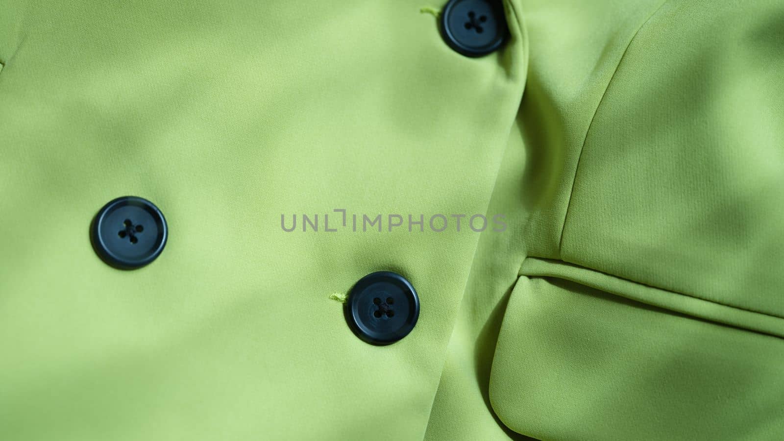 Closeup of custom made green jacket with black buttons. Strict business jacket and details