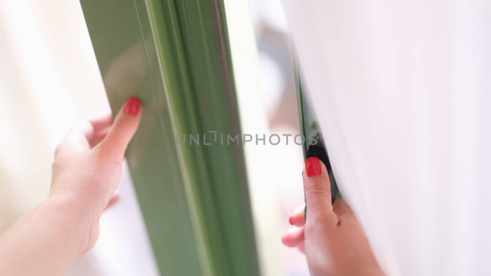 Woman tries to open door by holding window or door handle. Security and glass balcony doors