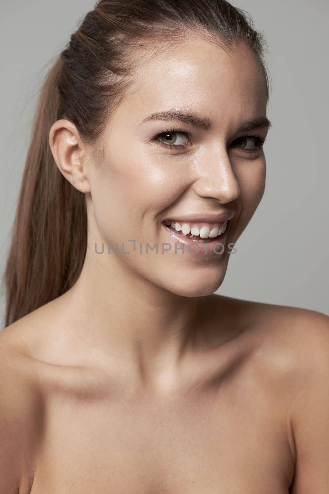 Beauty in simplicity. a beautiful young woman against a gray background