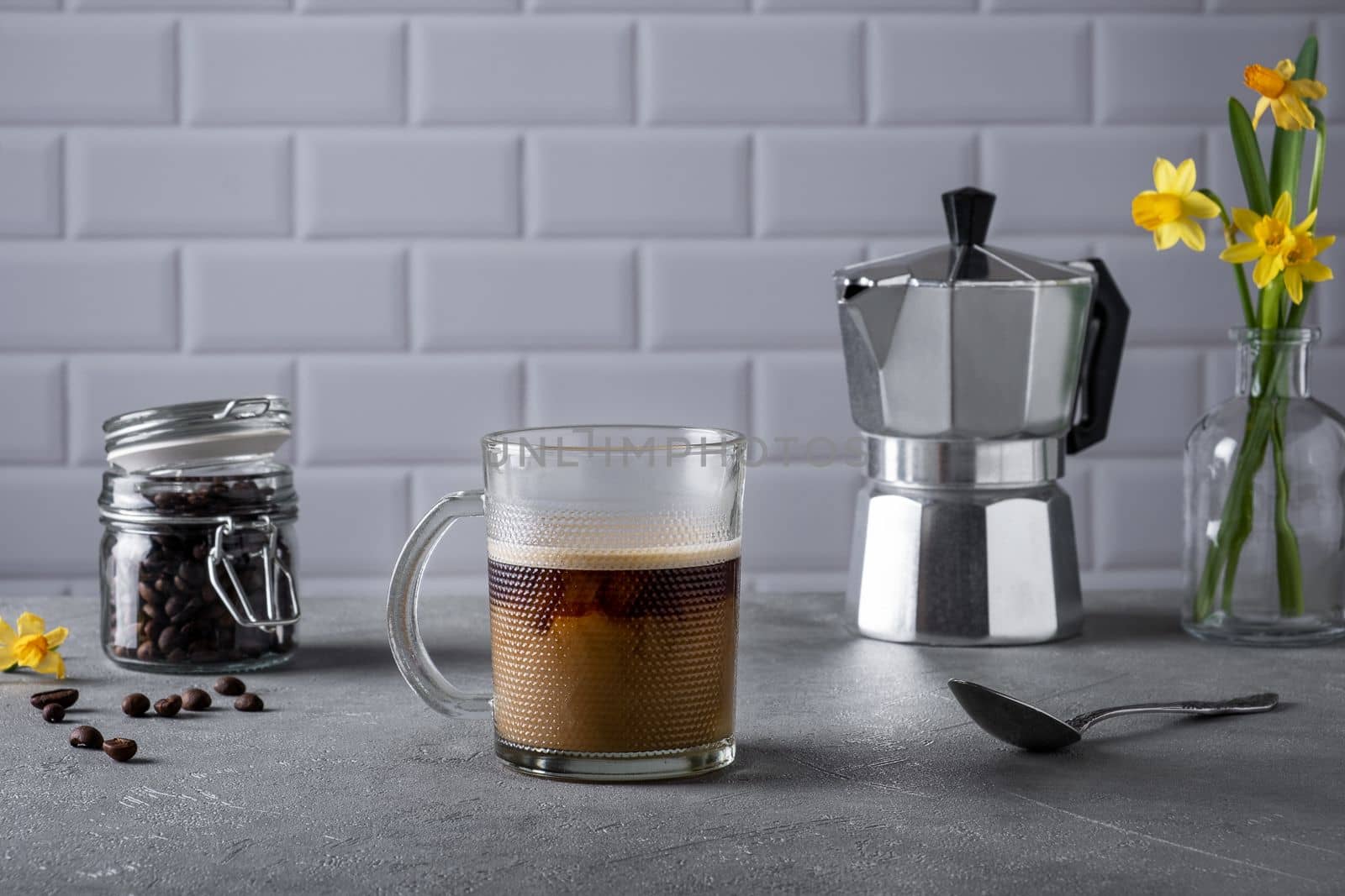 Still life with a glass cup of coffee with cream. Morning traditional coffee. Selective focus.