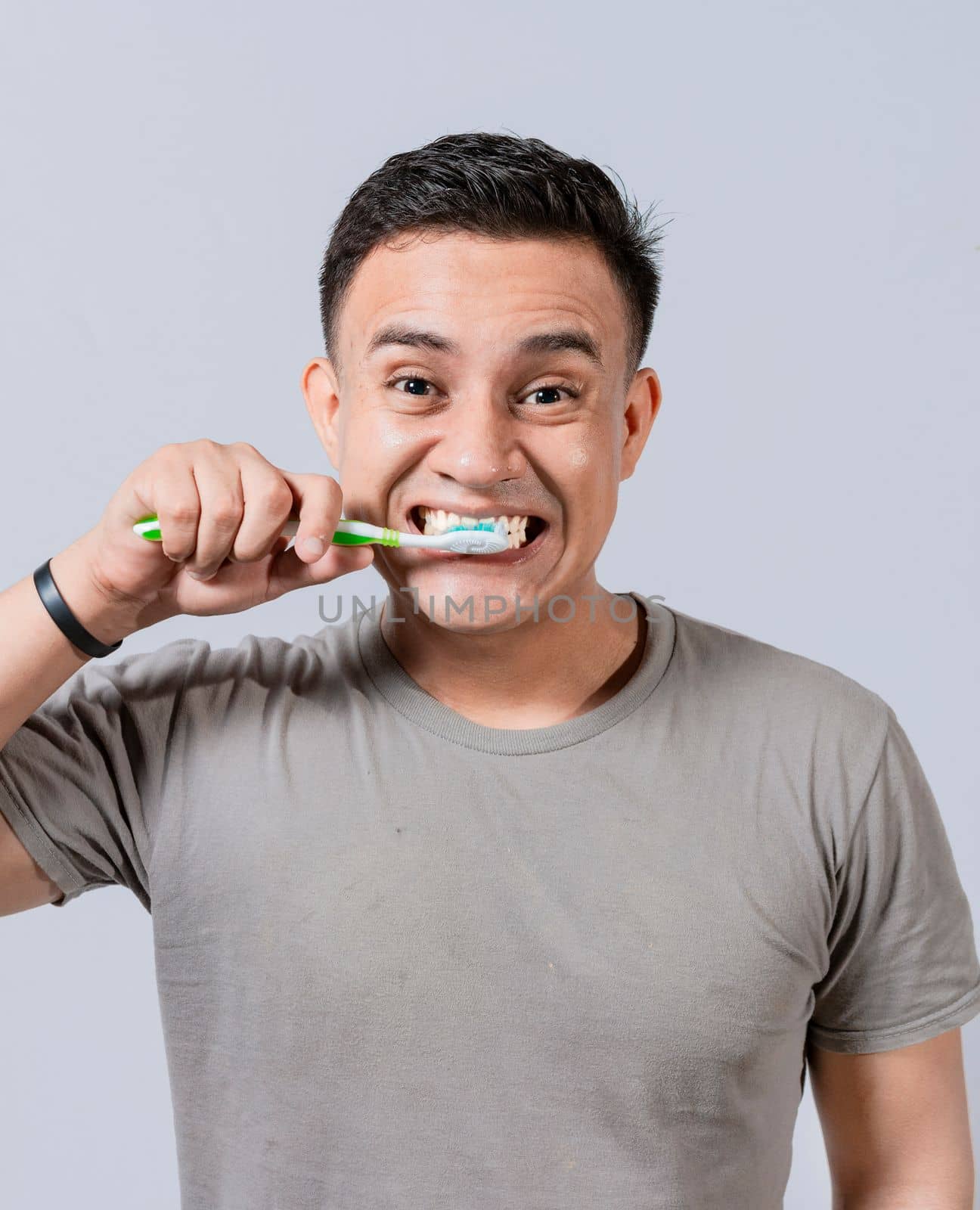 Face of handsome man brushing his teeth. Tooth brushing and care concept. Face of guy brushing teeth isolated. Oral and dental smile concept, Smiling man brushing his teeth isolated