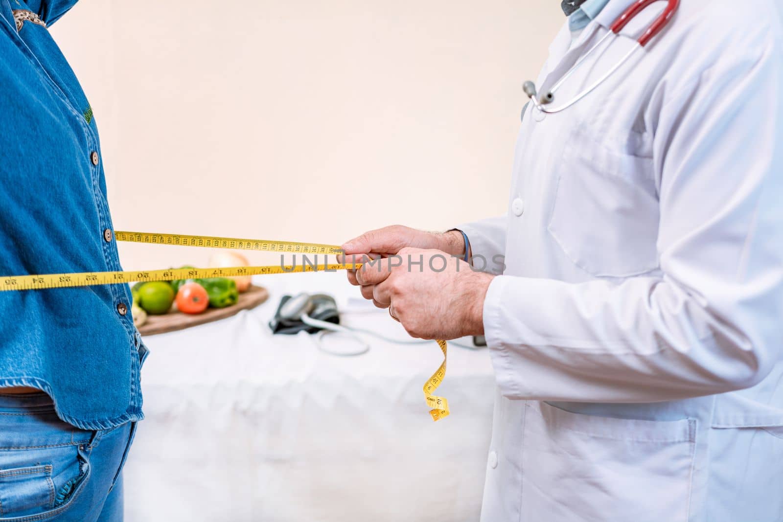 Hands of nutritionist measuring waist to female patient. Concept of weight loss and professional nutritionist, Close up of nutritionist measuring waist to female client.  by isaiphoto