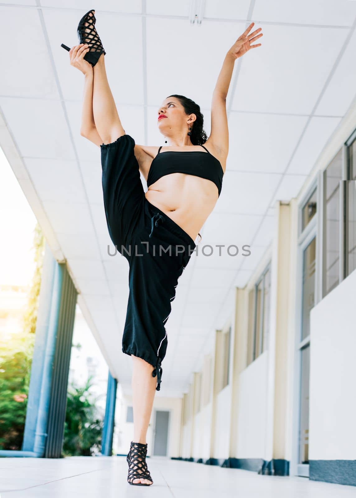 Dance girl doing flexibility in high heels. Woman dancer in heels doing yoga flexibilities. Dance artist woman doing acrobatics and flexibilities in heels. Artistic gymnastics concept