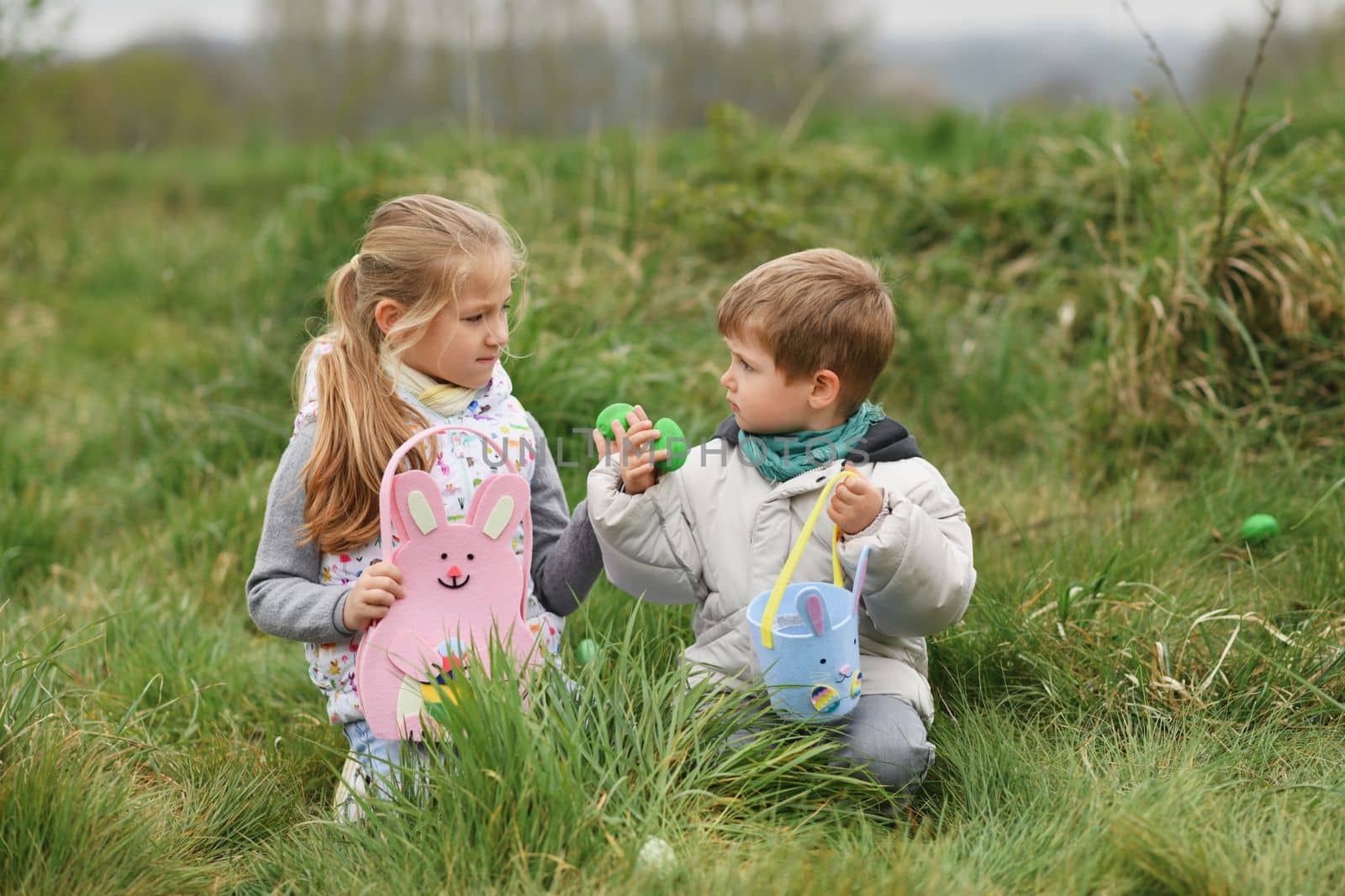 Children collects the eggs in a basket Easter