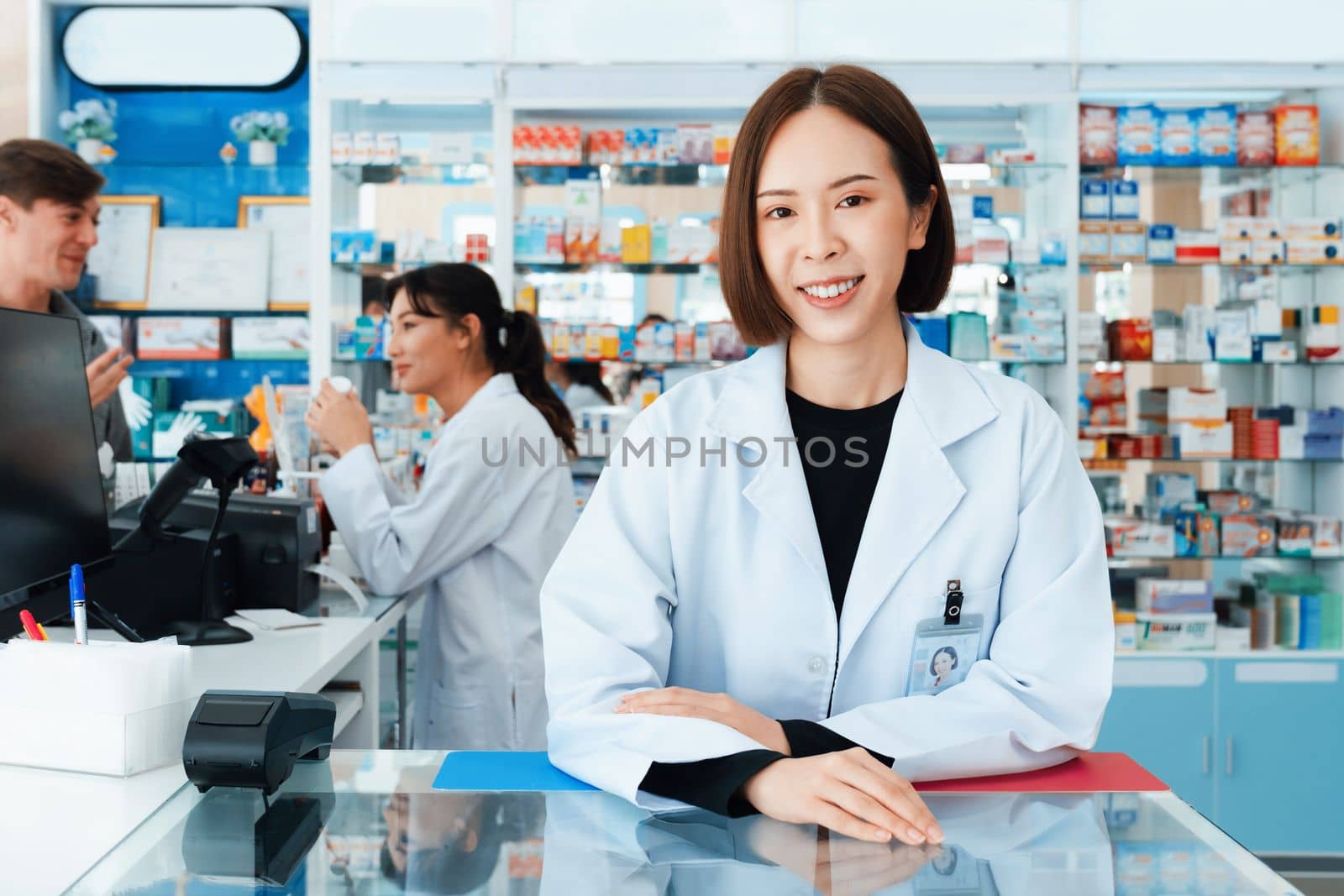 Portrait of affable asian pharmacist and qualified pharmaceutical, medicine pill bottle on shelf in background at pharmacy. Concept of pharmacist working on cashier talking to customer in drugstore.