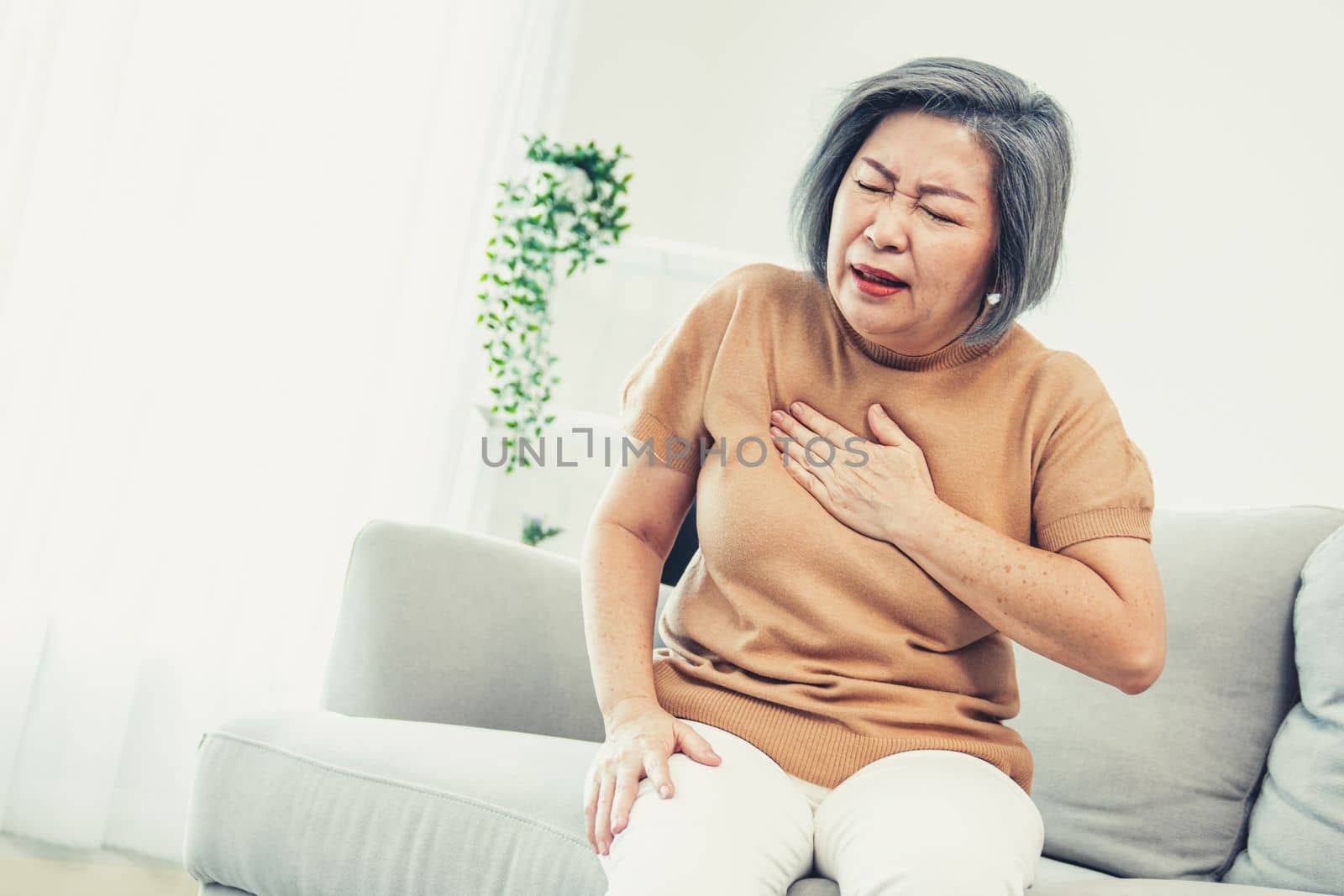 An agonizing elderly woman is experiencing chest pain. by biancoblue