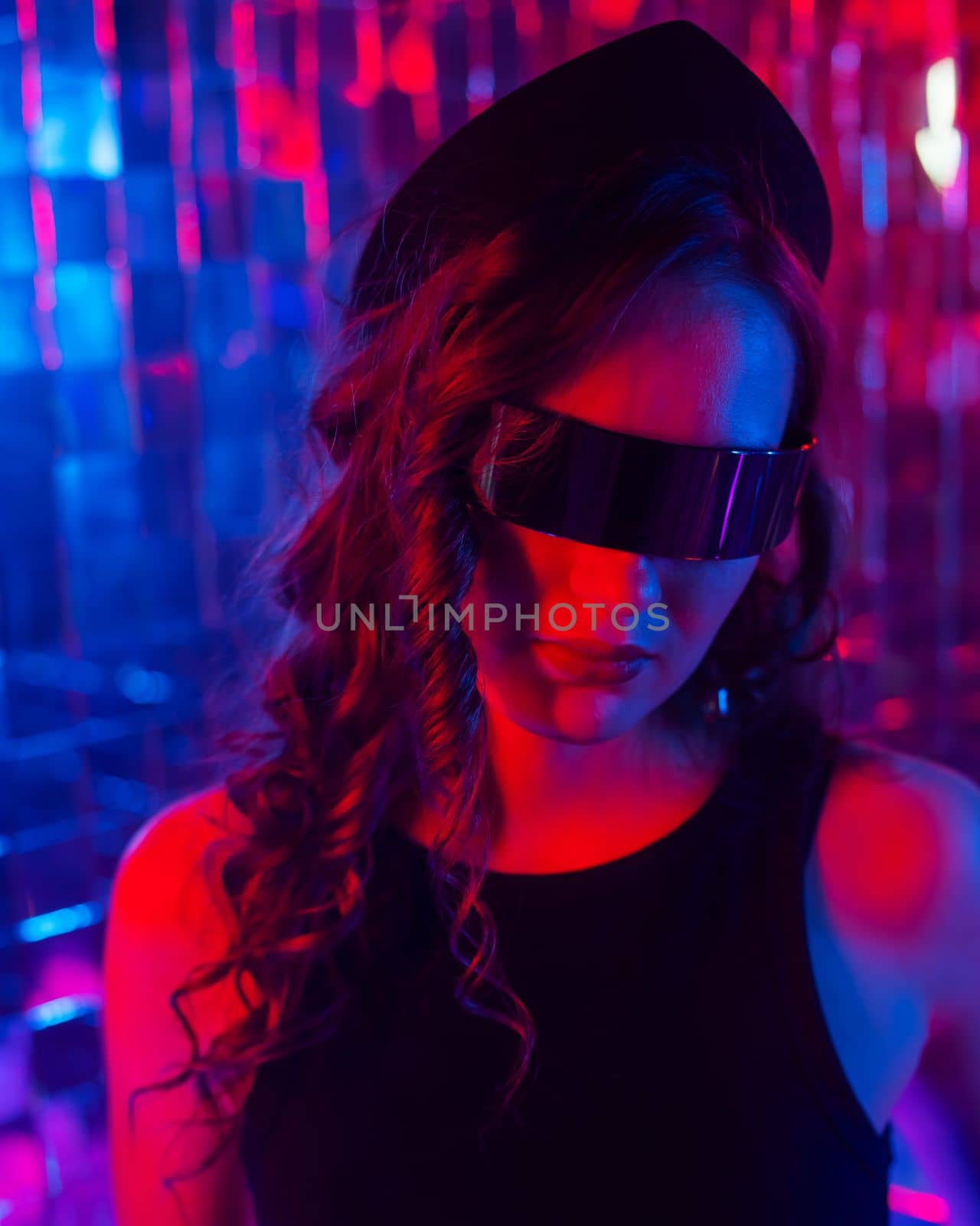 Close-up portrait of a caucasian woman in sunglasses in neon light against a mirror wall. by mrwed54