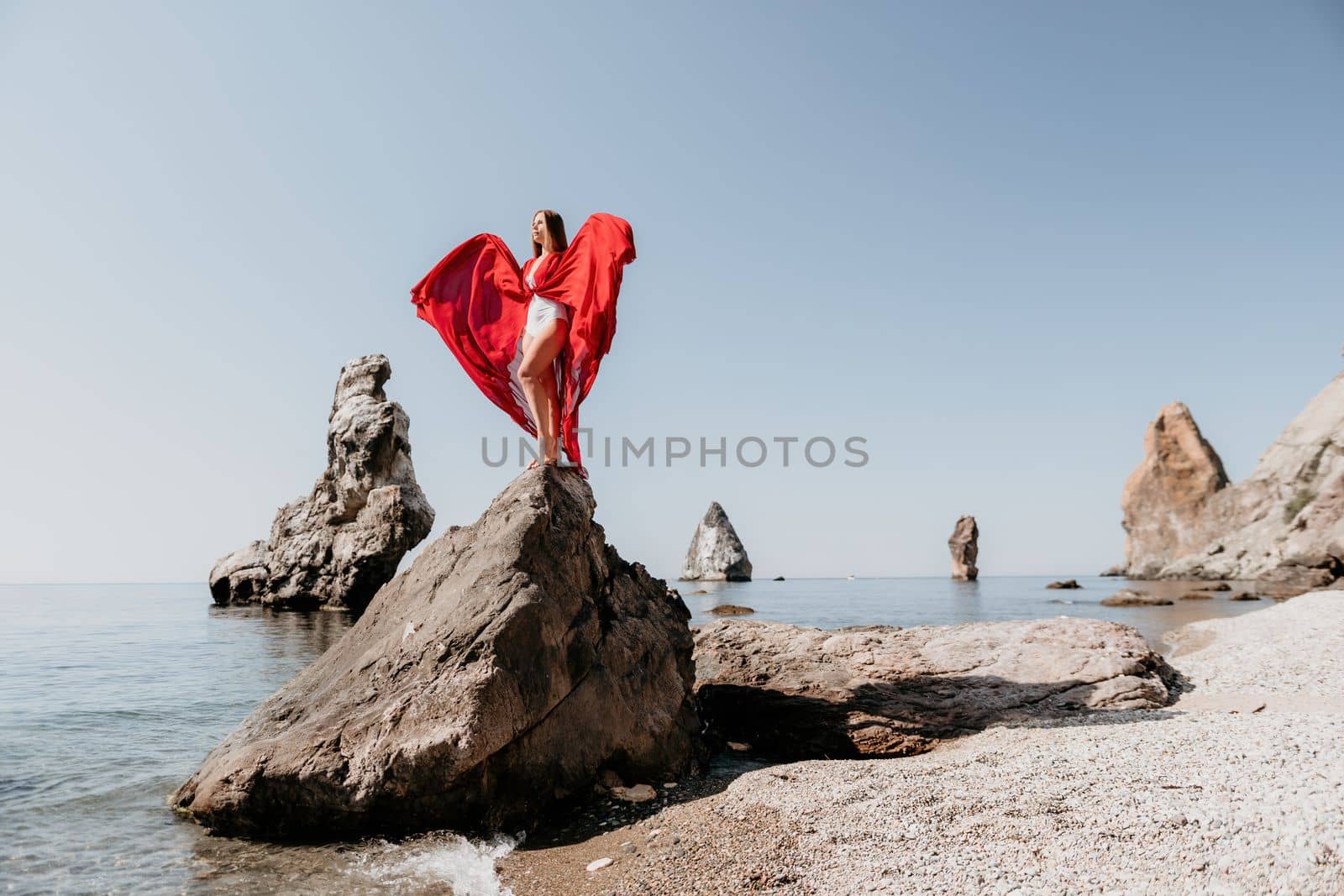 Woman travel sea. Happy tourist taking picture outdoors for memories. Woman traveler looks at the edge of the cliff on the sea bay of mountains, sharing travel adventure journey.