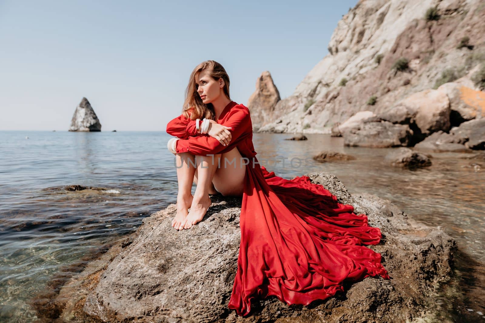 Woman travel sea. Happy tourist taking picture outdoors for memories. Woman traveler looks at the edge of the cliff on the sea bay of mountains, sharing travel adventure journey.