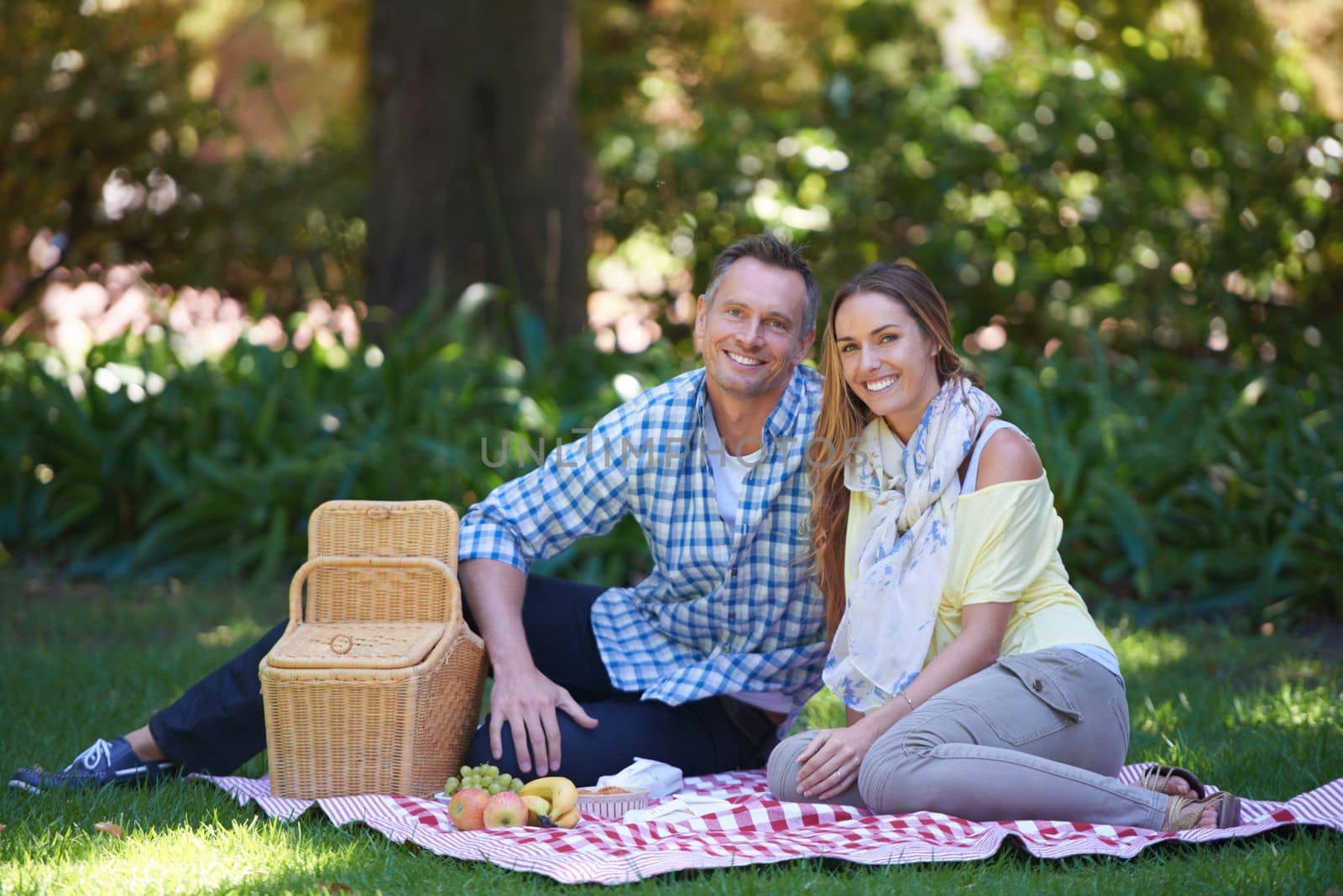Romance is in the air. A mature couple Portrait of a married couple enjoying a picnic outdoors. by YuriArcurs