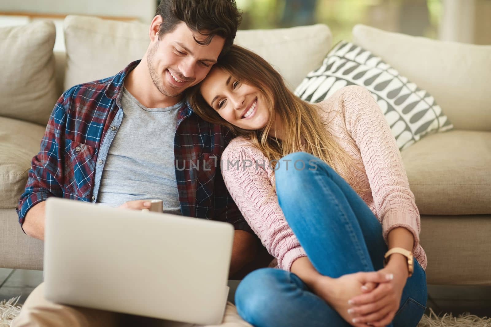 I saw this post and thought of you. a happy young couple using a laptop together while relaxing in their lounge at home. by YuriArcurs