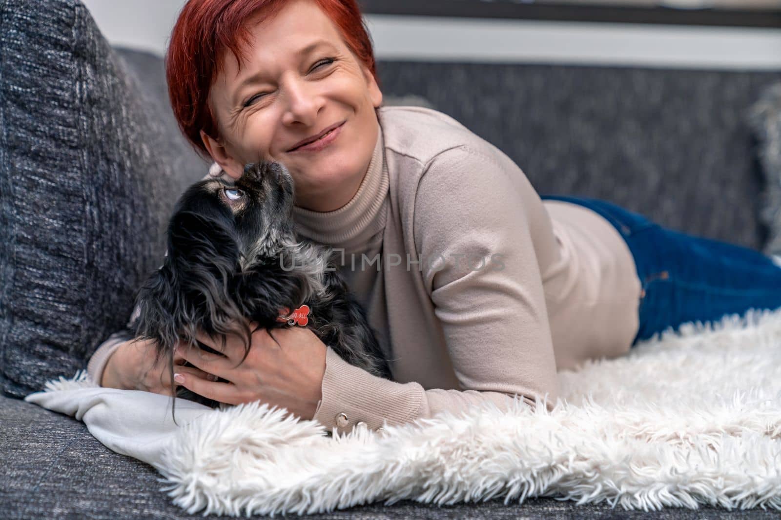 woman with dog on couch by Edophoto