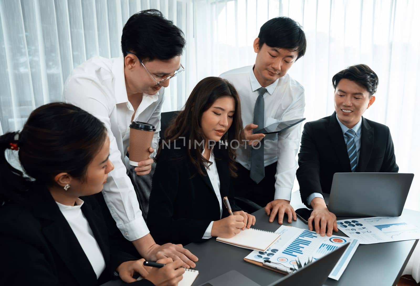 Harmony in office concept as business people analyzing dashboard paper together in workplace. Young colleagues give ideas at manager desk for discussion or strategy planning about project.