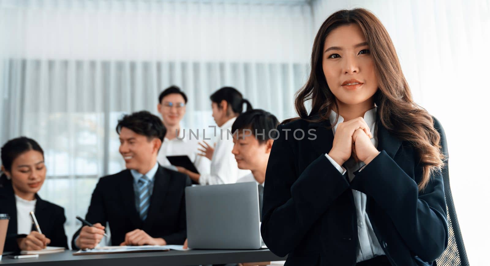 Focus portrait of female manger, businesswoman in the harmony meeting room with blurred of colleagues working together, analyzing financial paper report and dashboard data in background.