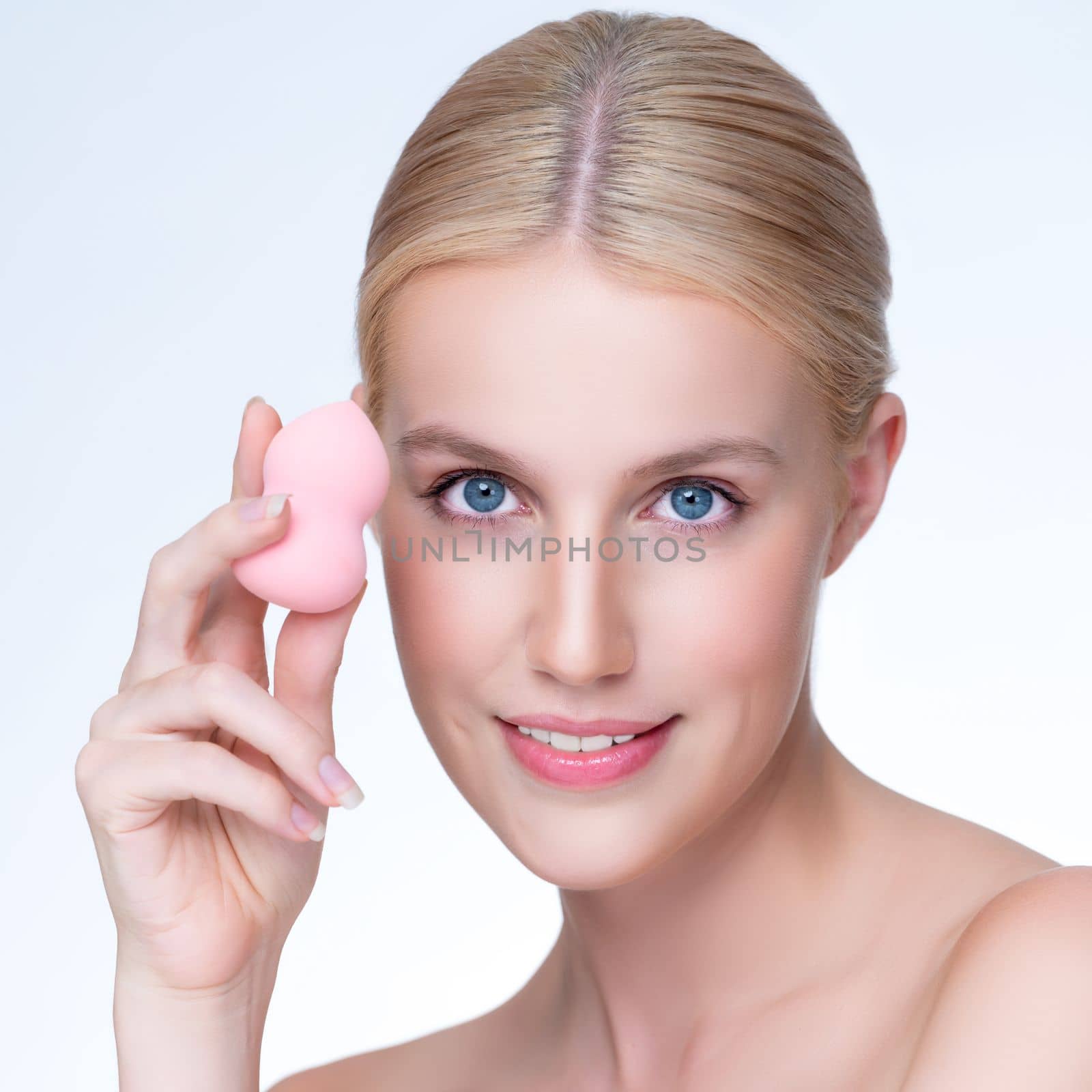 Closeup personable natural makeup woman using powder puff for facial makeup. by biancoblue