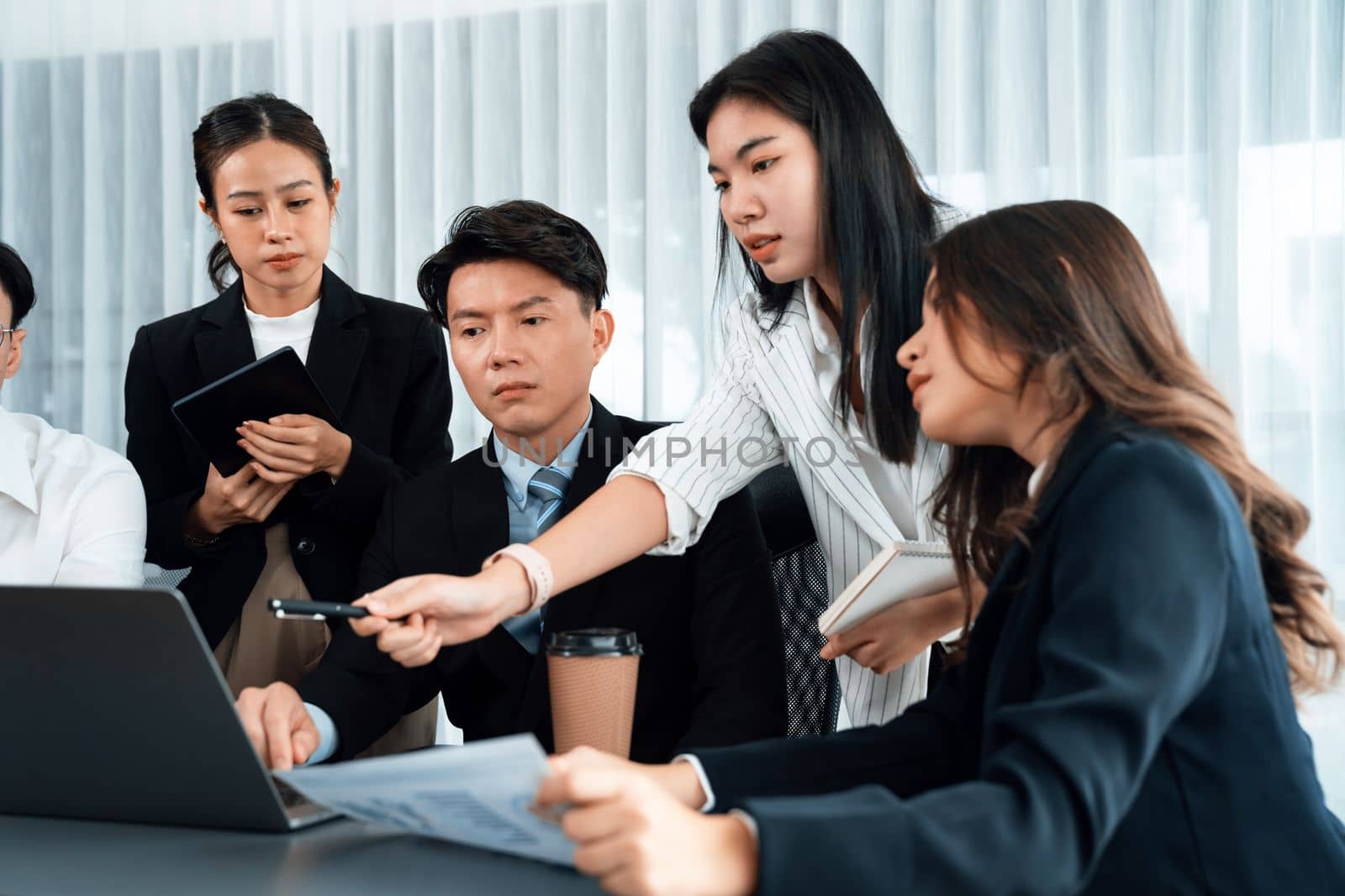 Harmony in office concept as business people analyzing dashboard paper together in workplace. Young colleagues give ideas at manager desk for discussion or strategy planning about project.