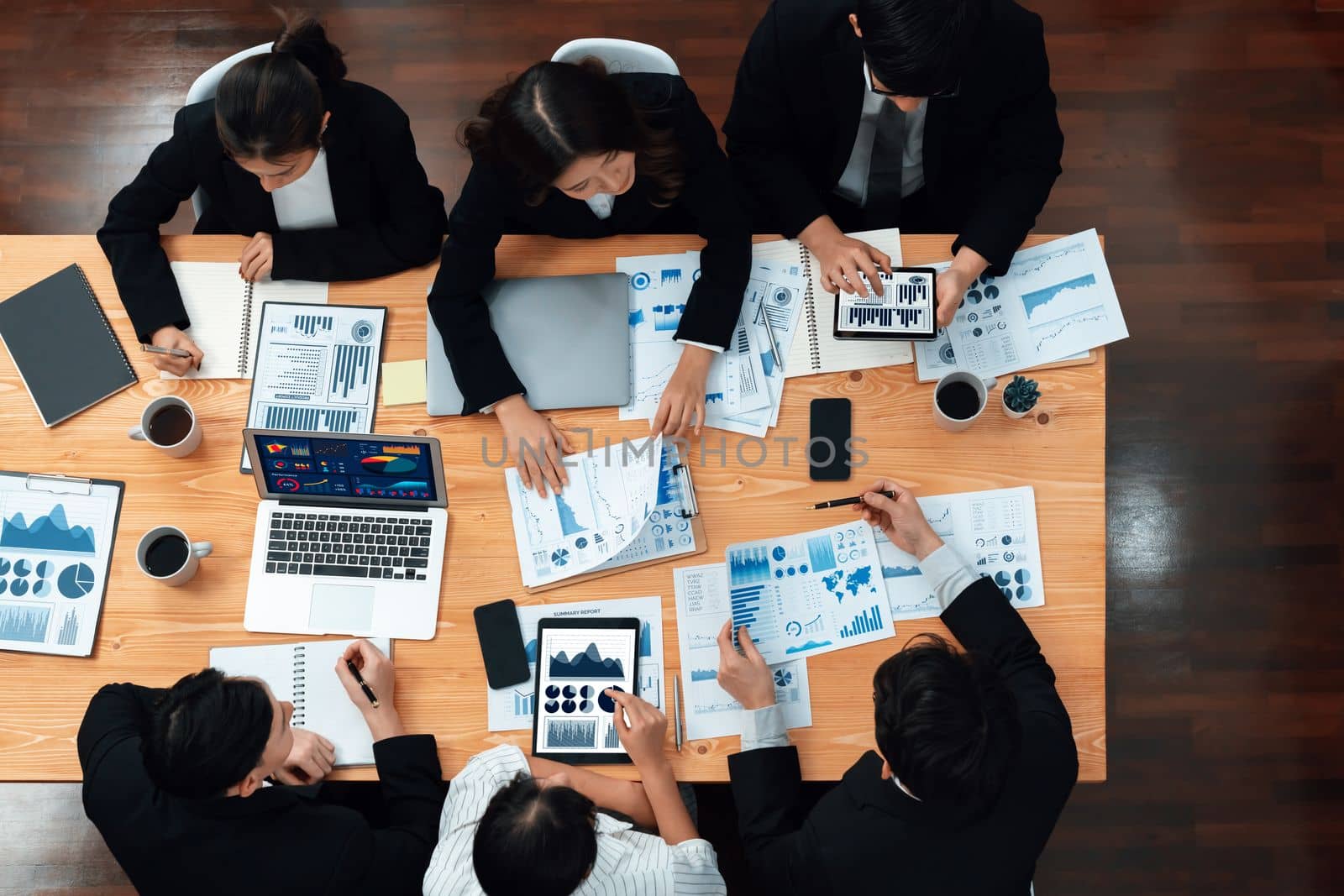 Top-view business team of financial data analysis meeting with business intelligence, report paper and dashboard on laptop for marketing strategy. Business people working together in office of harmony