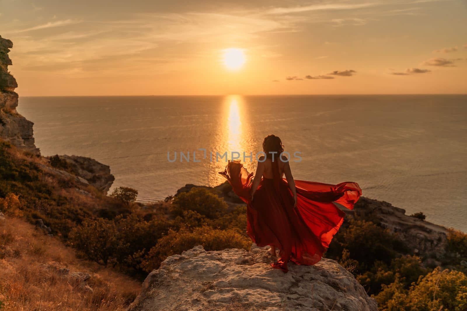 Woman in red dress, fashion model in evening dress, soaring in the street, sunset.