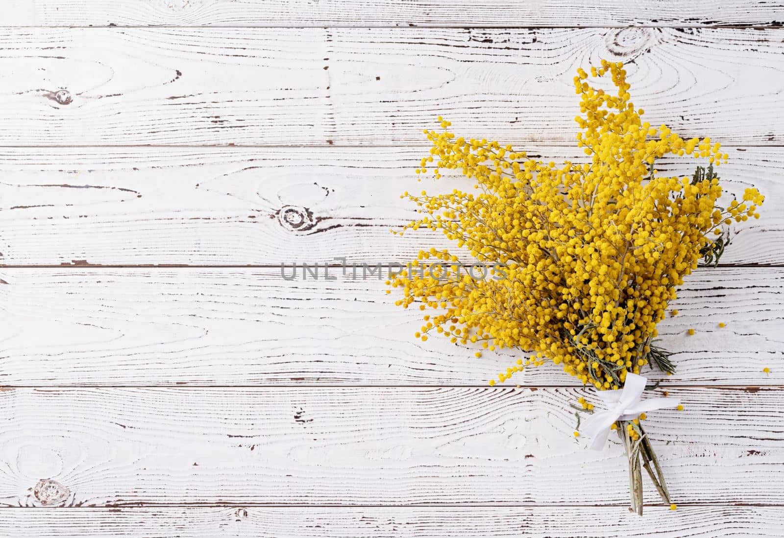 Frame of yellow mimosa flowers bouquet on wooden bakground. Spring concept. Flat lay. Top view, banner