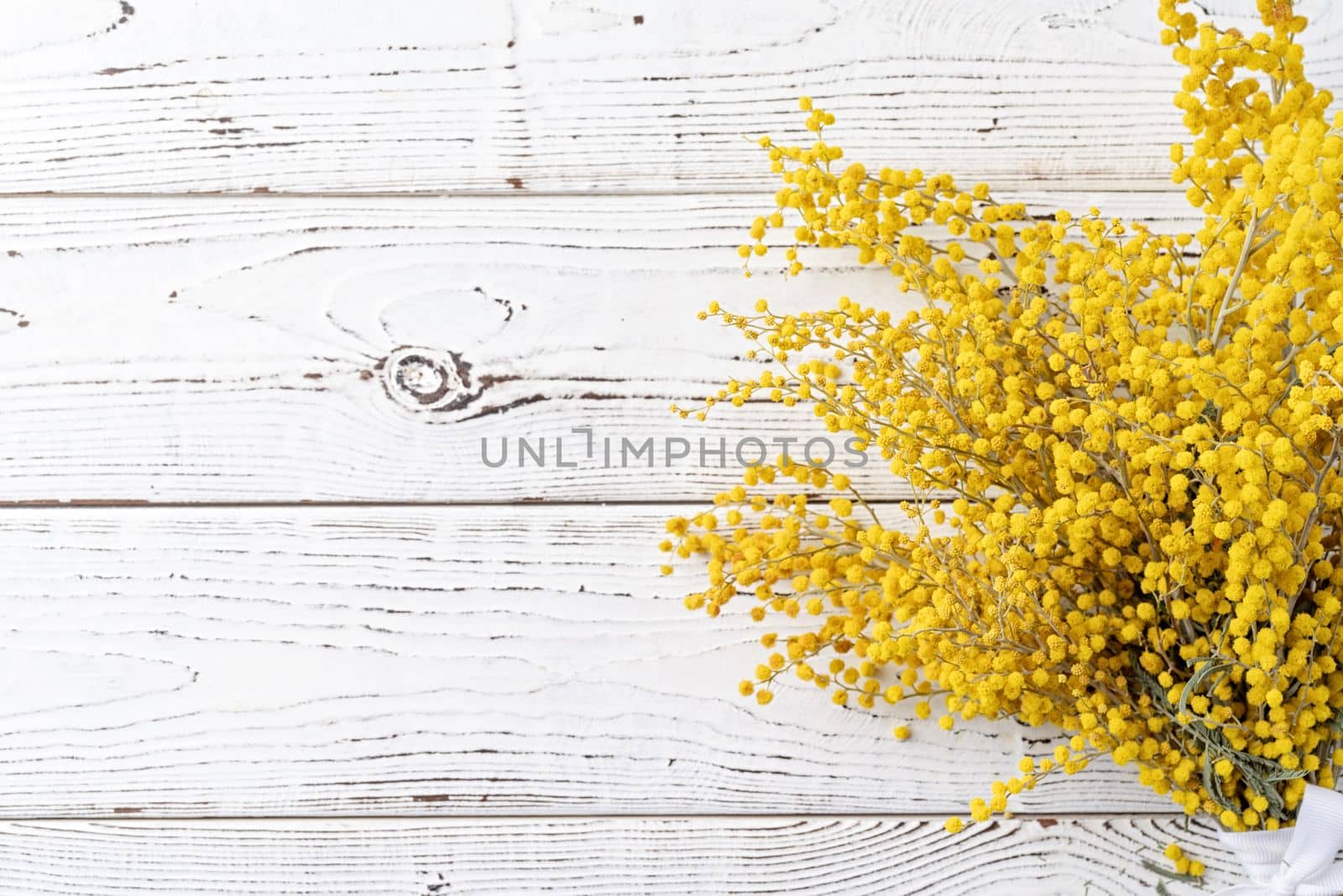 Frame of yellow mimosa flowers bouquet on wooden bakground. Spring concept. Flat lay. Top view, banner