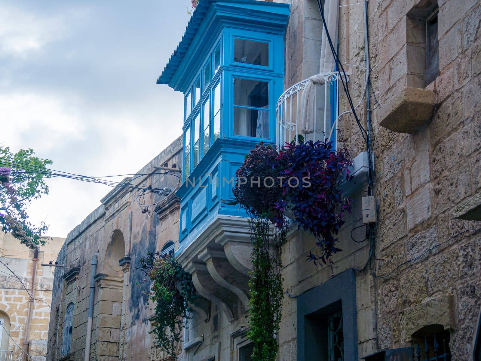 Fragment of the building's facade with traditional wooden ornate balconies painted in Valletta, Malta. High quality photo