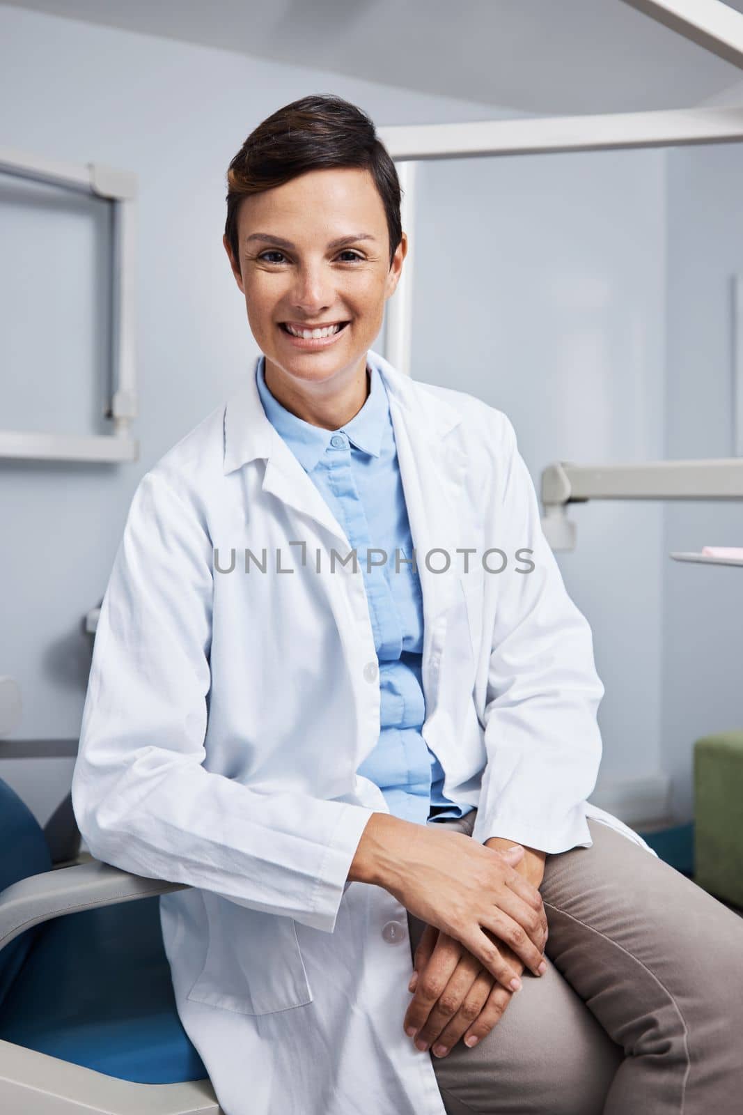 We brighten smiles beyond our patients expectations. Portrait of a confident young woman working in a dentists office. by YuriArcurs