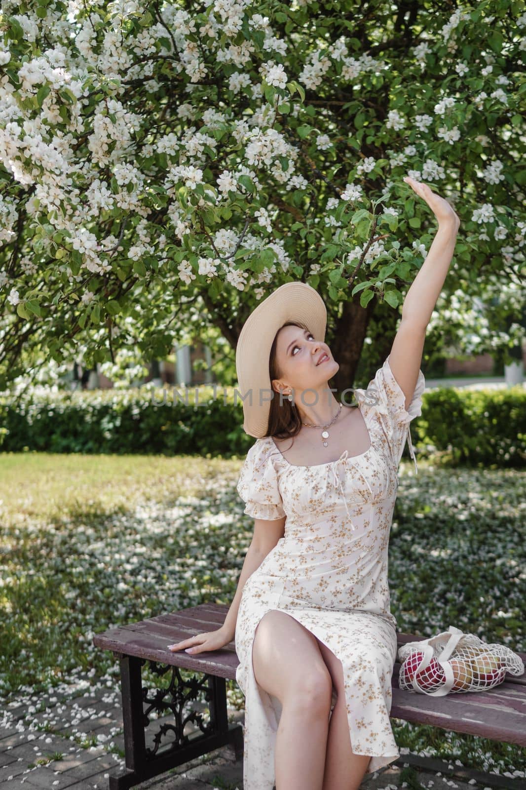 An attractive long-haired woman walks in the spring in the park of blooming apple trees. by Annu1tochka