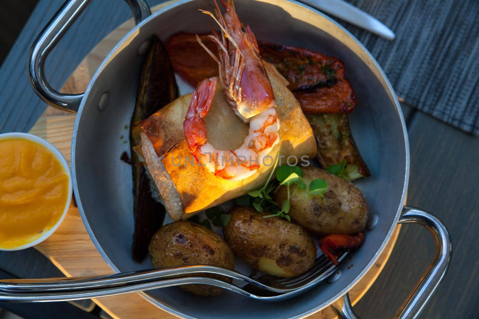 Close up of delicious roll fish with king prawn, peppers, potatoes, aubergines accompanied with squash sauce