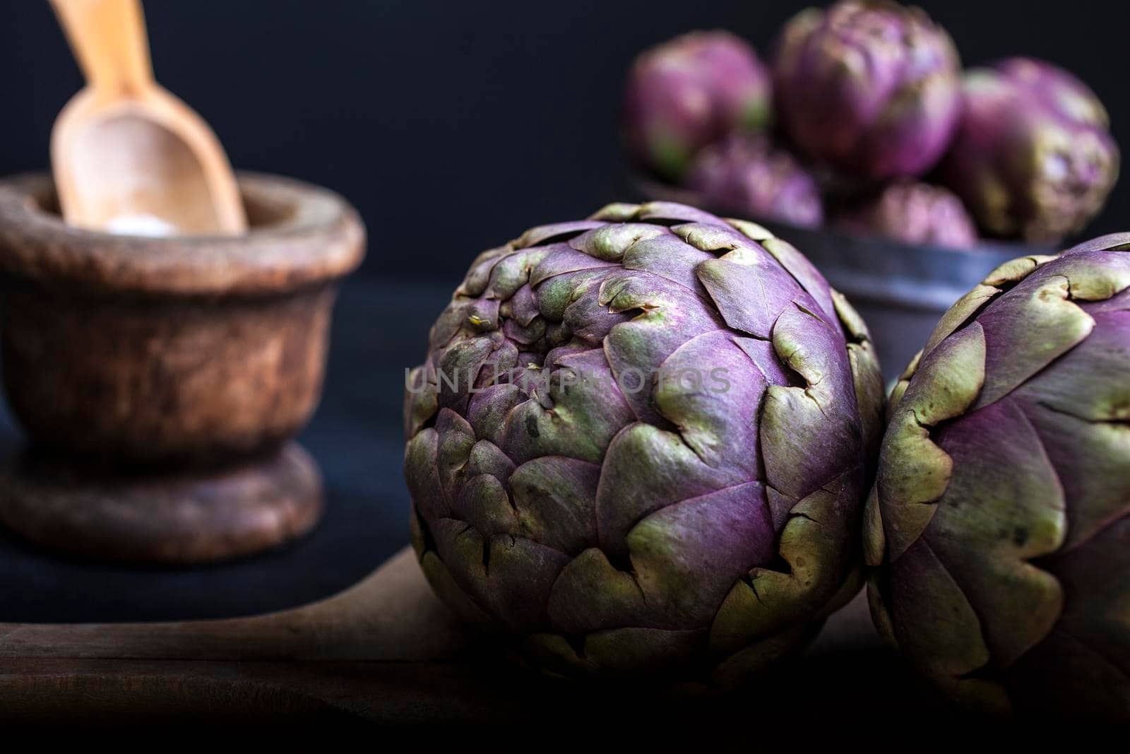 Close up of fresh artichokens on dark background