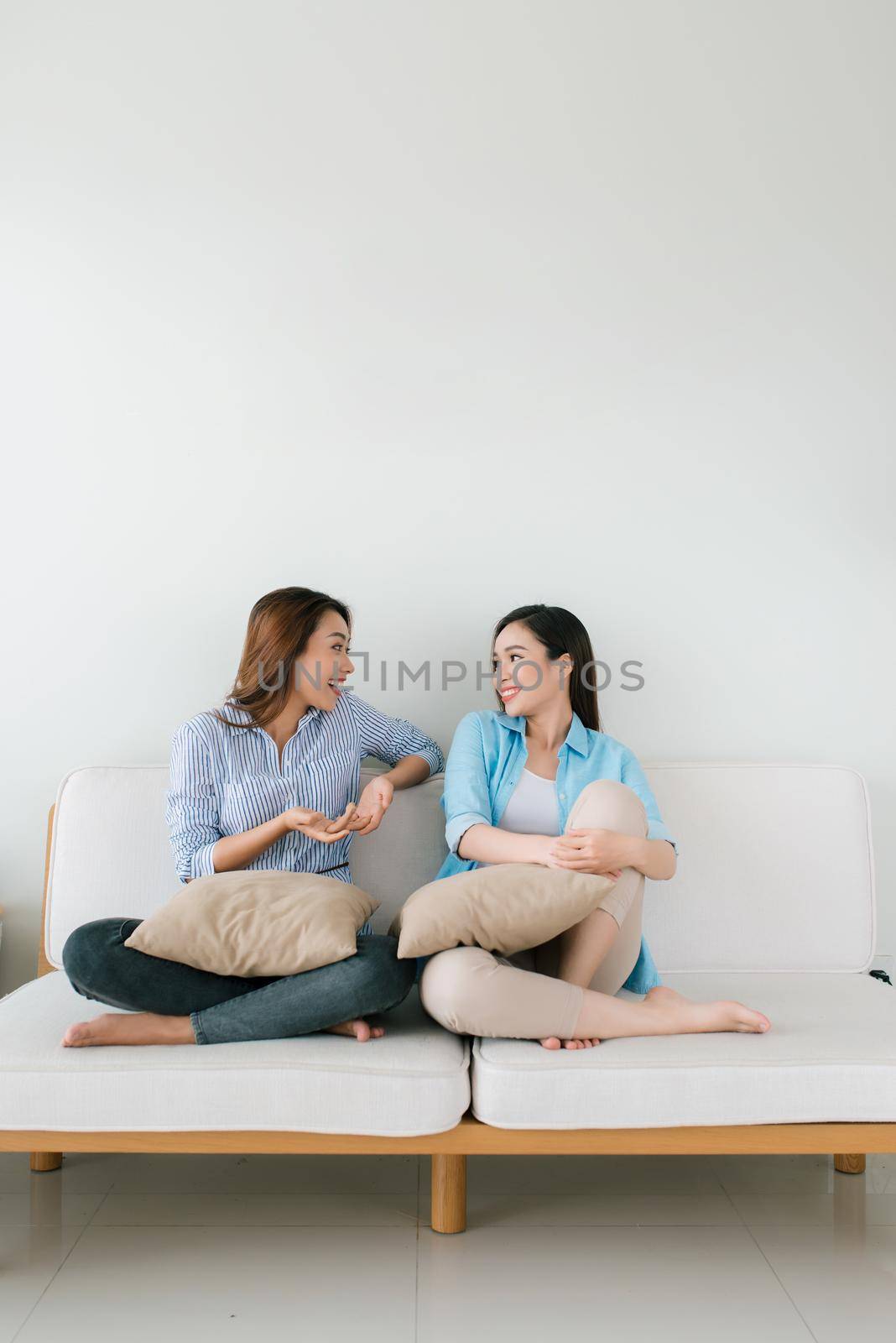 Two girlfriends having a talk on the couch  at home